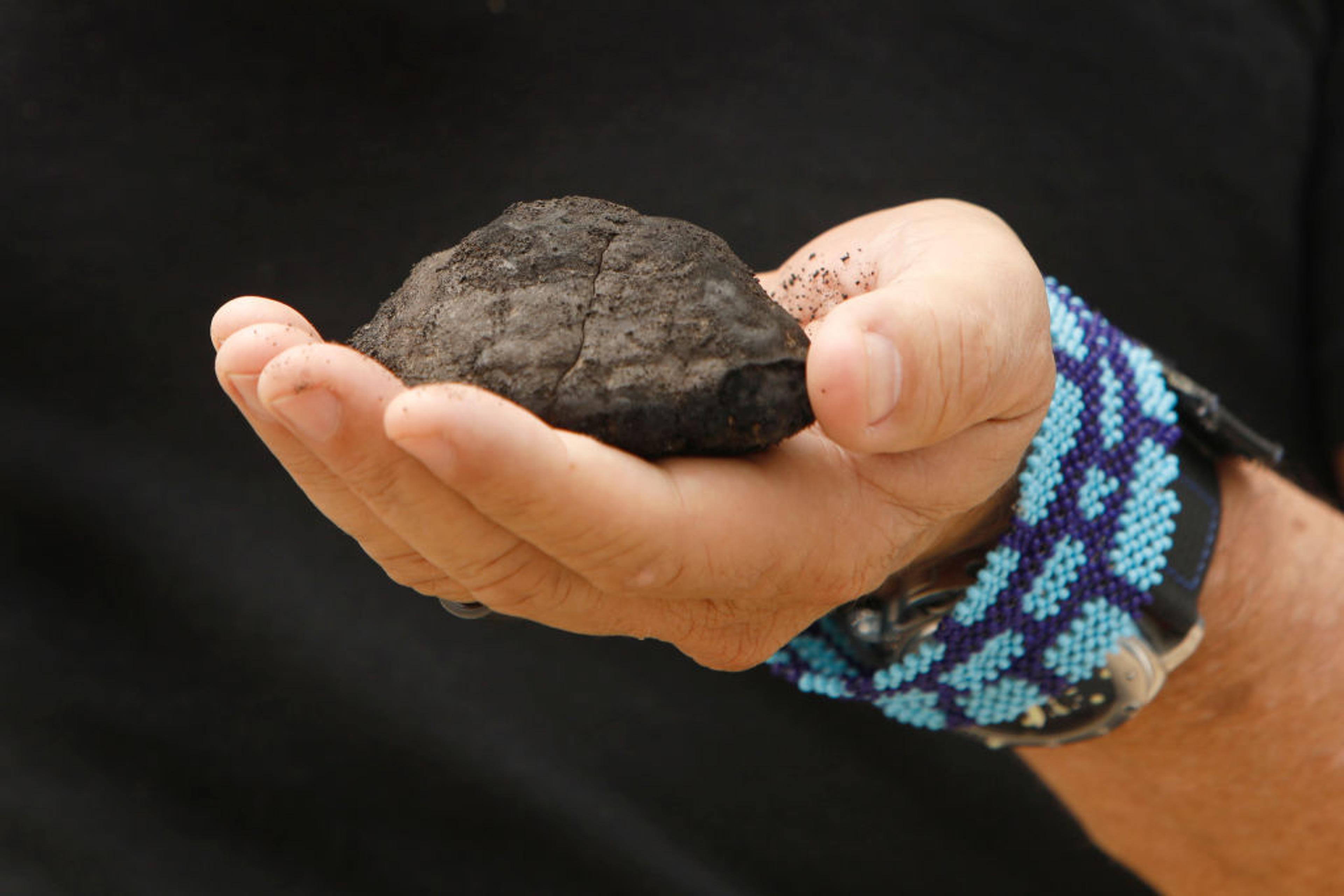 CEO of The Metals Company holds a nodule brought up from the sea floor. The company plans to mine the seafloor for these nodules in the Clarion Clipperton Zone of the Pacific Ocean.