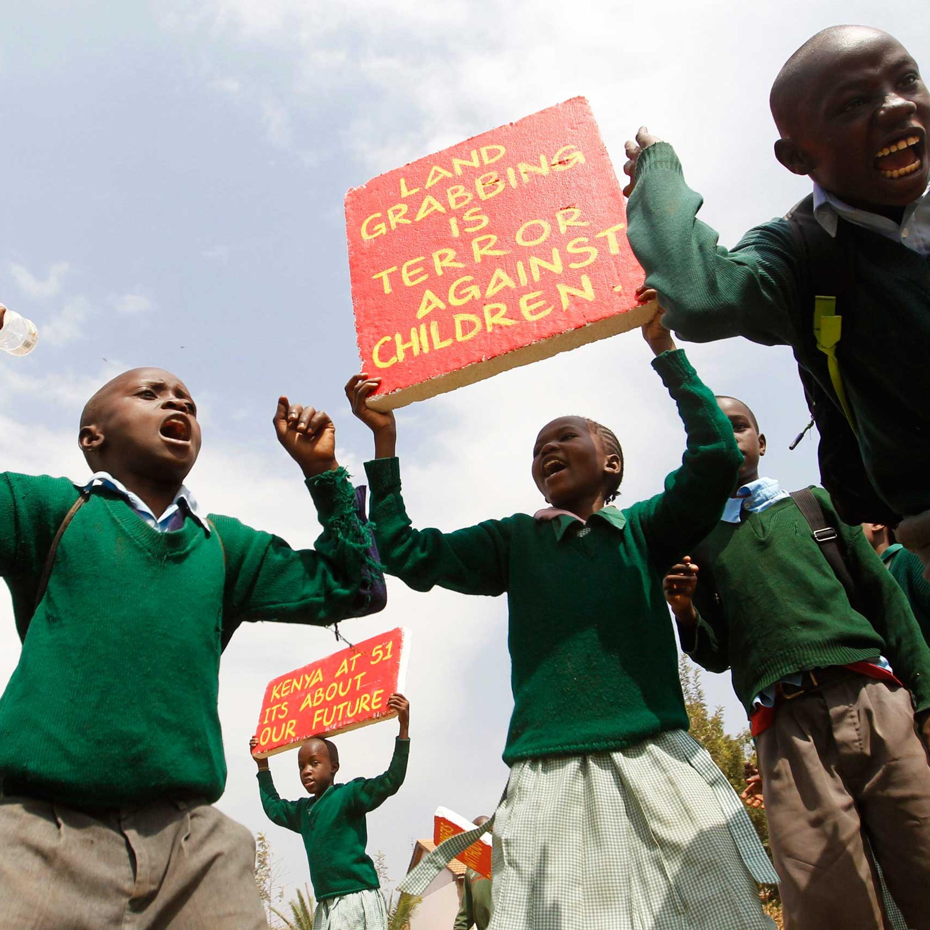 Students from Langata primary school hold placards as they protest against a perimeter wall illegally erected by a private developer around their school playground in Kenya's capital Nairobi, Jan. 19, 2015.
