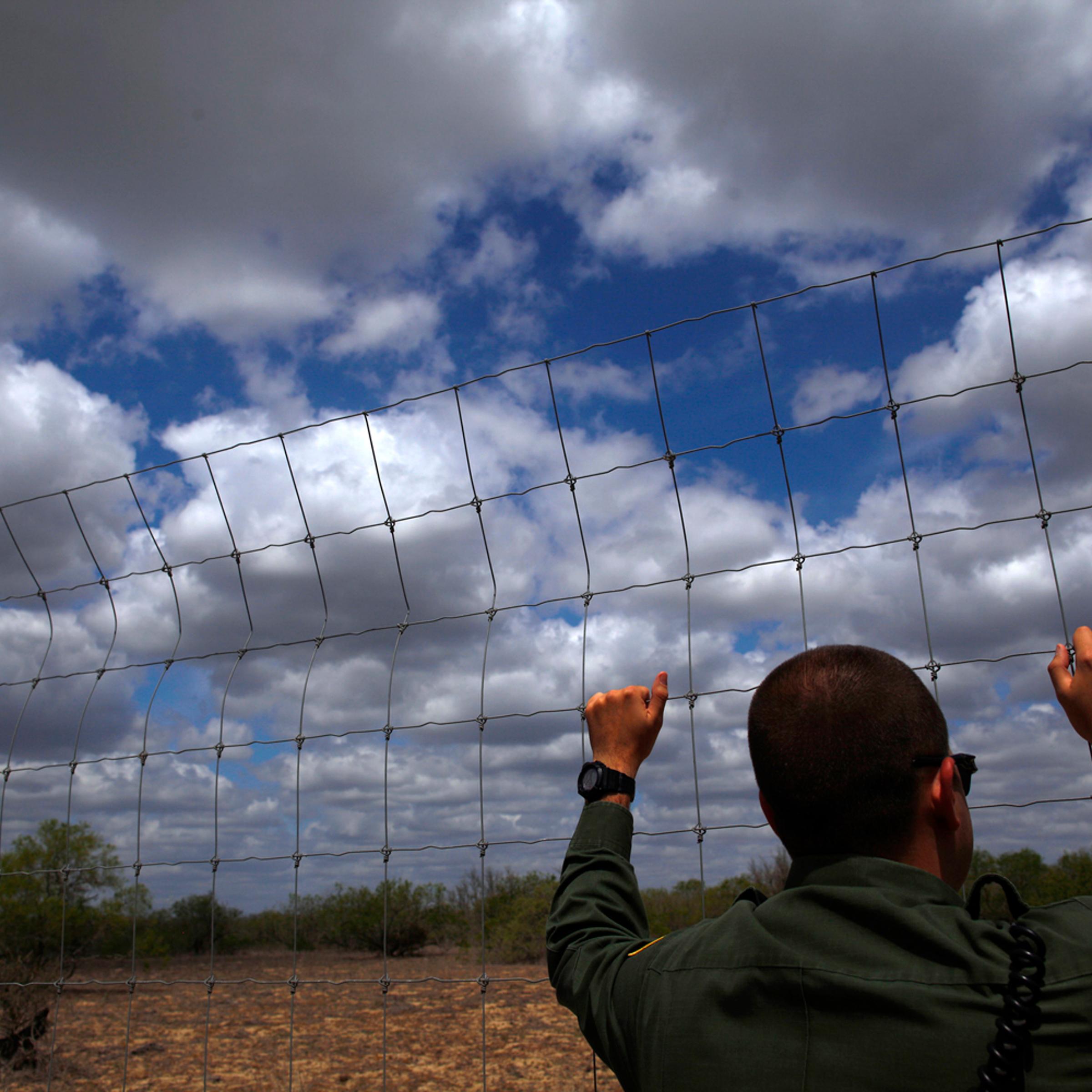 A U.S. Border Patrol agent looks out at the desert near Falfurrias, Texas