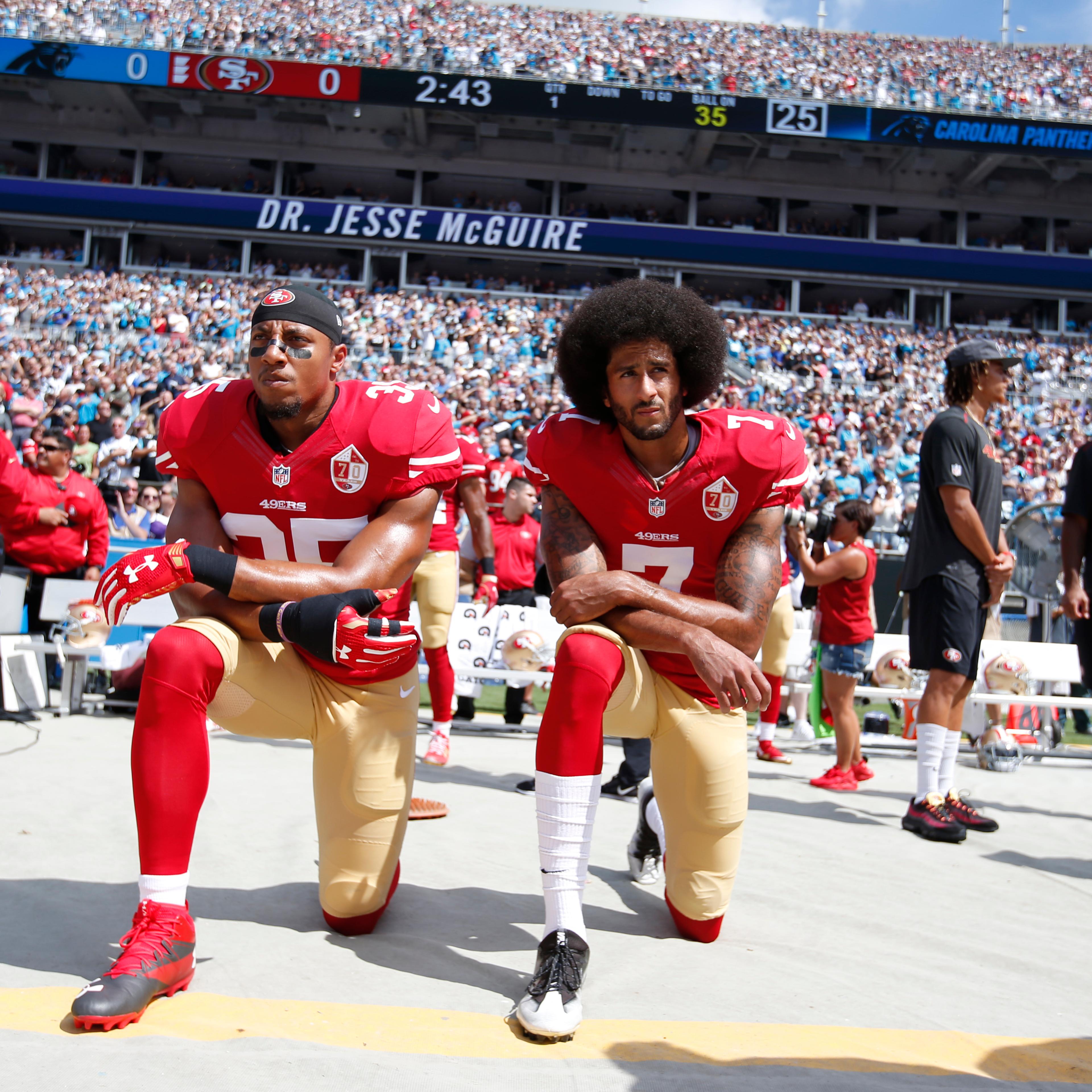 Eric Reid #35 and Colin Kaepernick #7 of the San Francisco 49ers kneel on the sideline, during the anthem, prior to the game against the Carolina Panthers at Bank of America Stadium in Charlotte, N.C., on Sept. 18, 2016.
