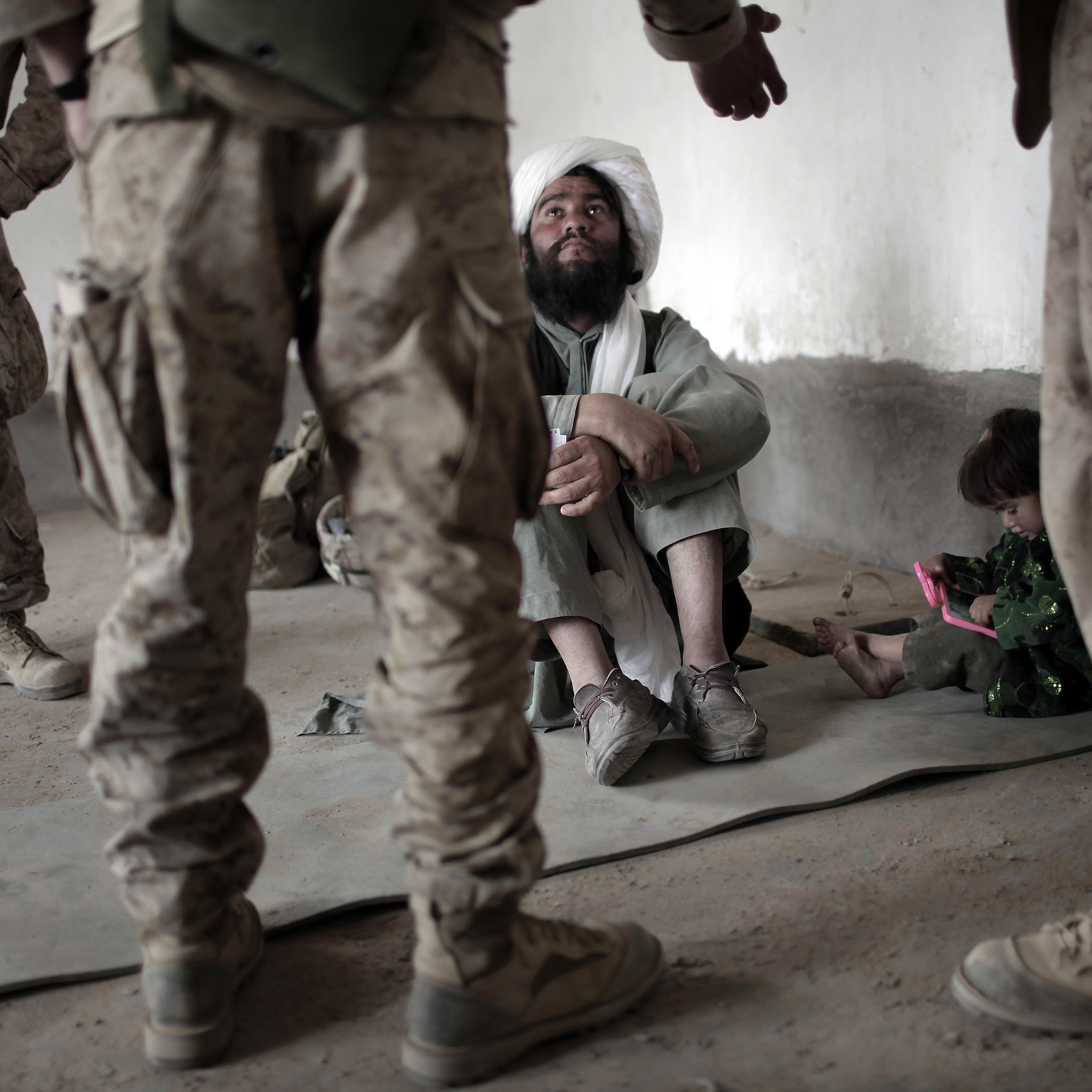 An imam listens to an interpreter for U.S. forces in Marjah, southern Afghanistan, in 2010.