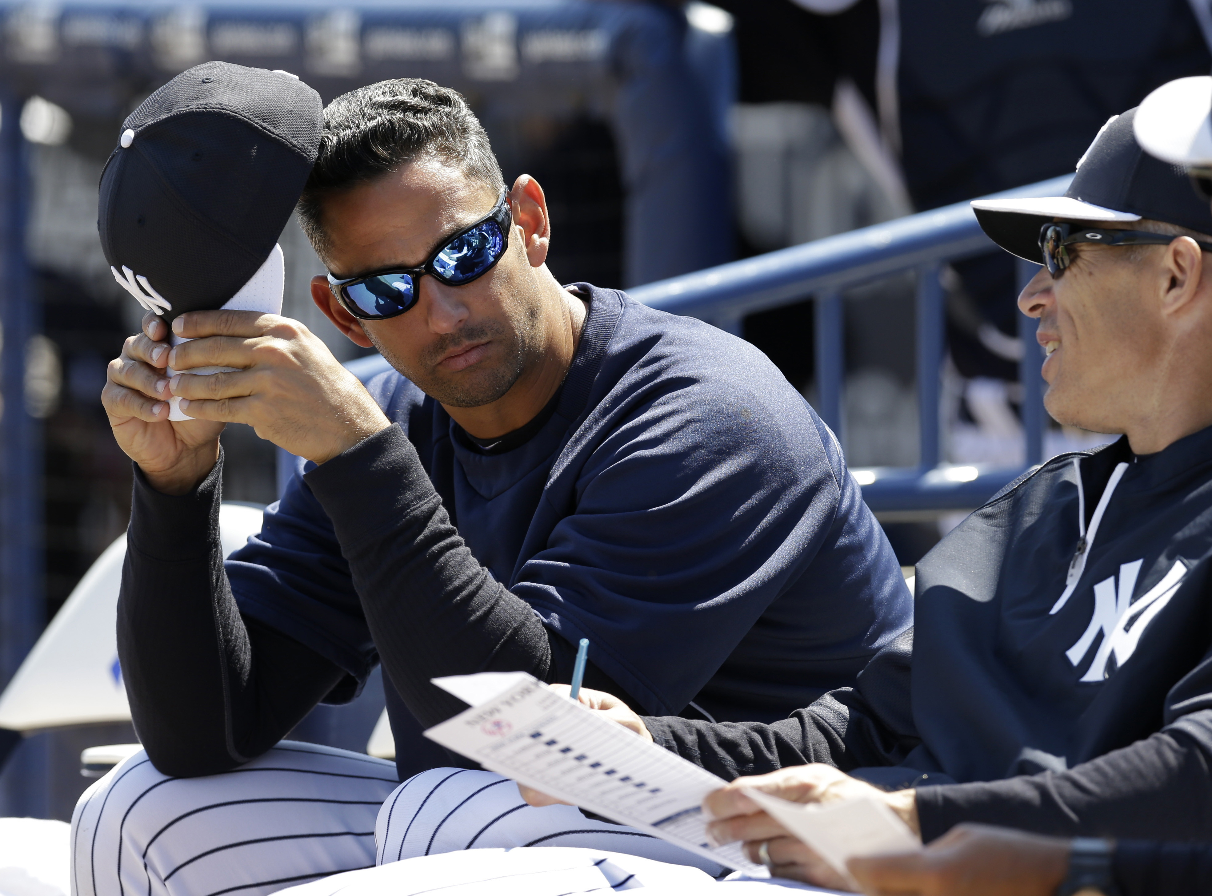 Former New York Yankees catcher Jorge Posada, left, in camp as a guest instructor, sits with New York Yankees manager Joe Girardi before a spring training baseball game against the Miami Marlins in Tampa