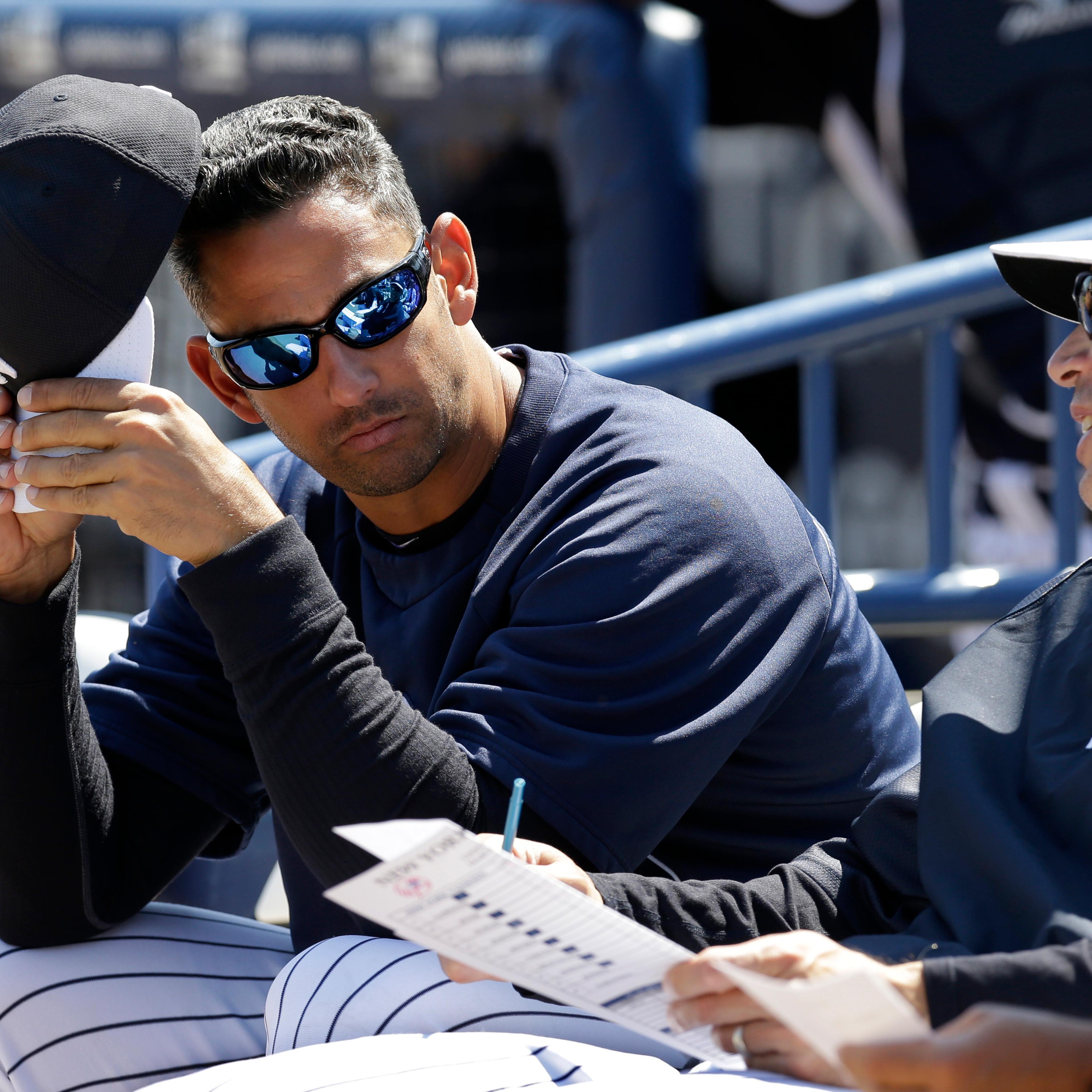 Former New York Yankees catcher Jorge Posada, left, in camp as a guest instructor, sits with New York Yankees manager Joe Girardi before a spring training baseball game against the Miami Marlins in Tampa