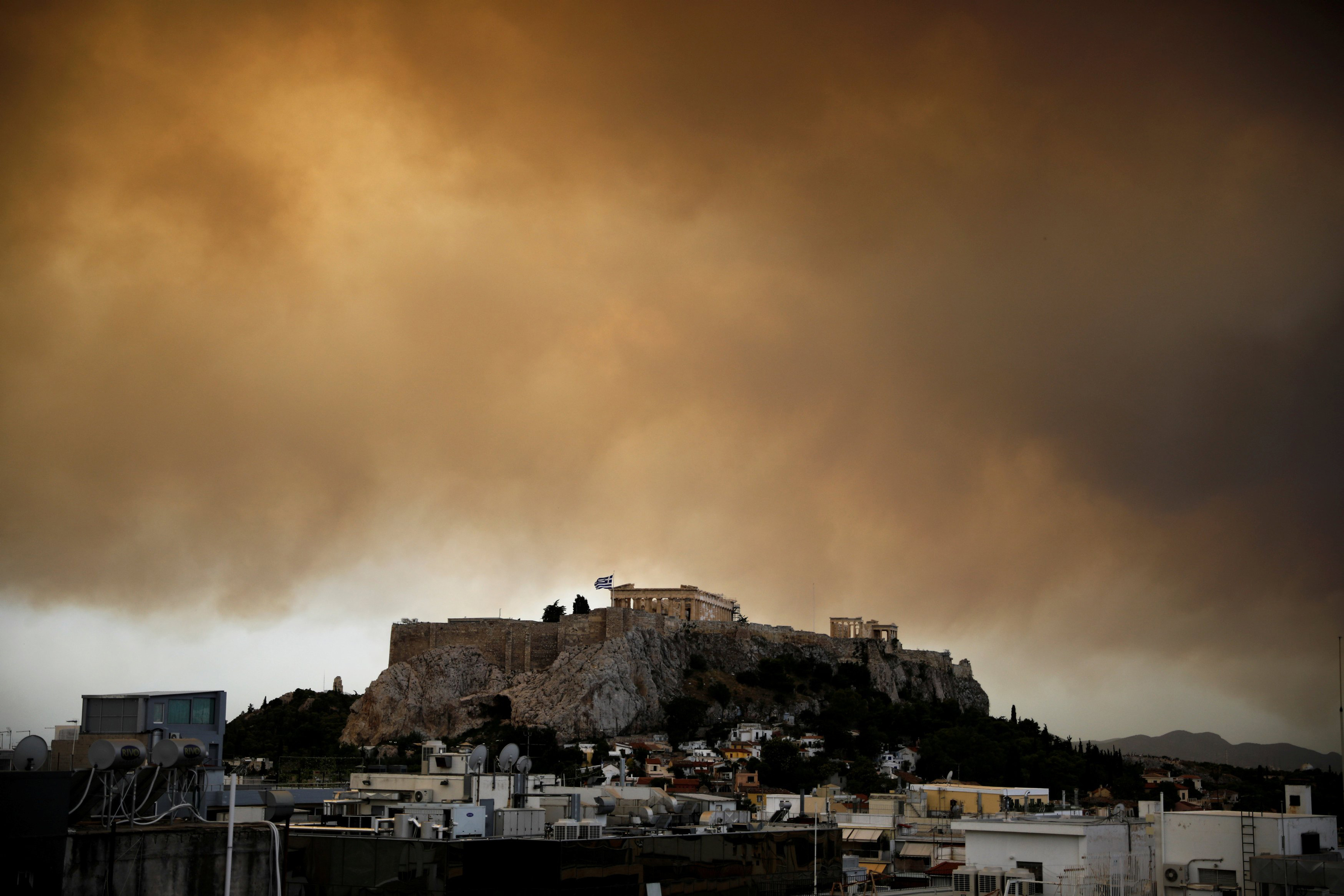 Smoke from a wildfire burning outside Athens is seen over the Parthenon temple atop the Acropolis hill in Athens