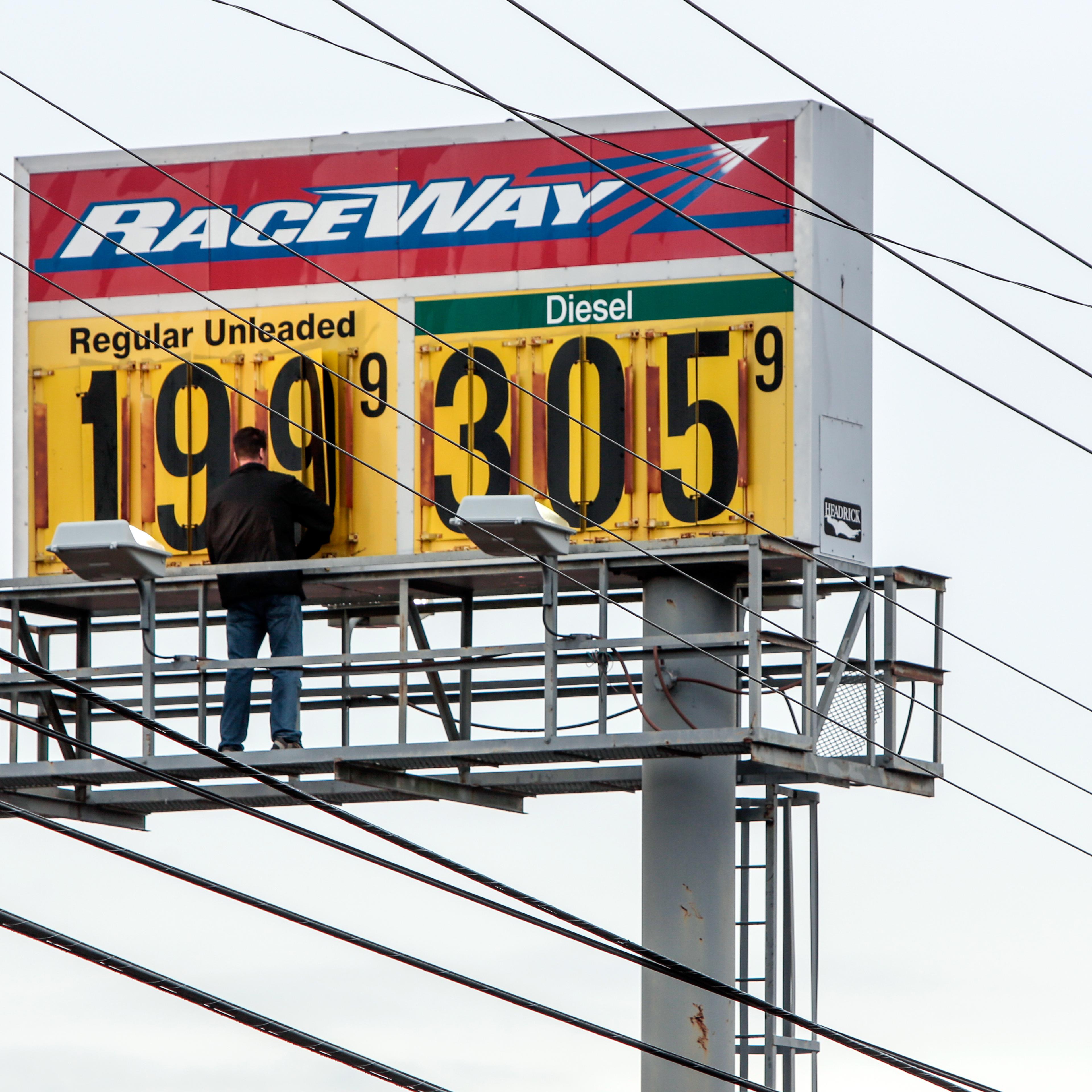 Mark Monaham, owner of the Raceway gas station in McComb, Miss., changes his fuel price billboard, Friday, Dec. 19, 2014. Gas prices throughout the region continue to fall as oil prices plummet.