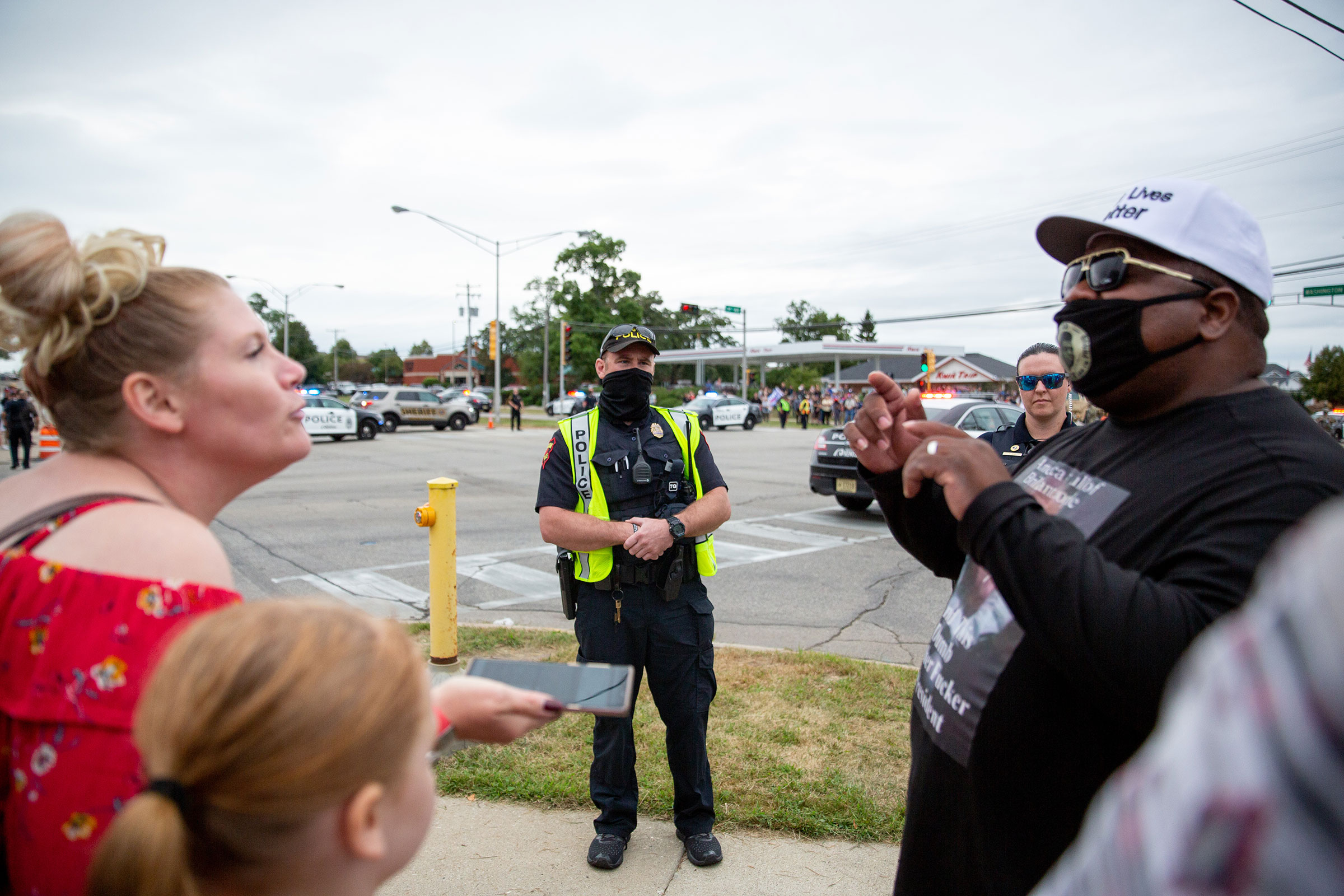 Police watch protestors during President Trump's meeting at Bradford High School in Kenosha, Wis., on Sept. 1, 2020. 