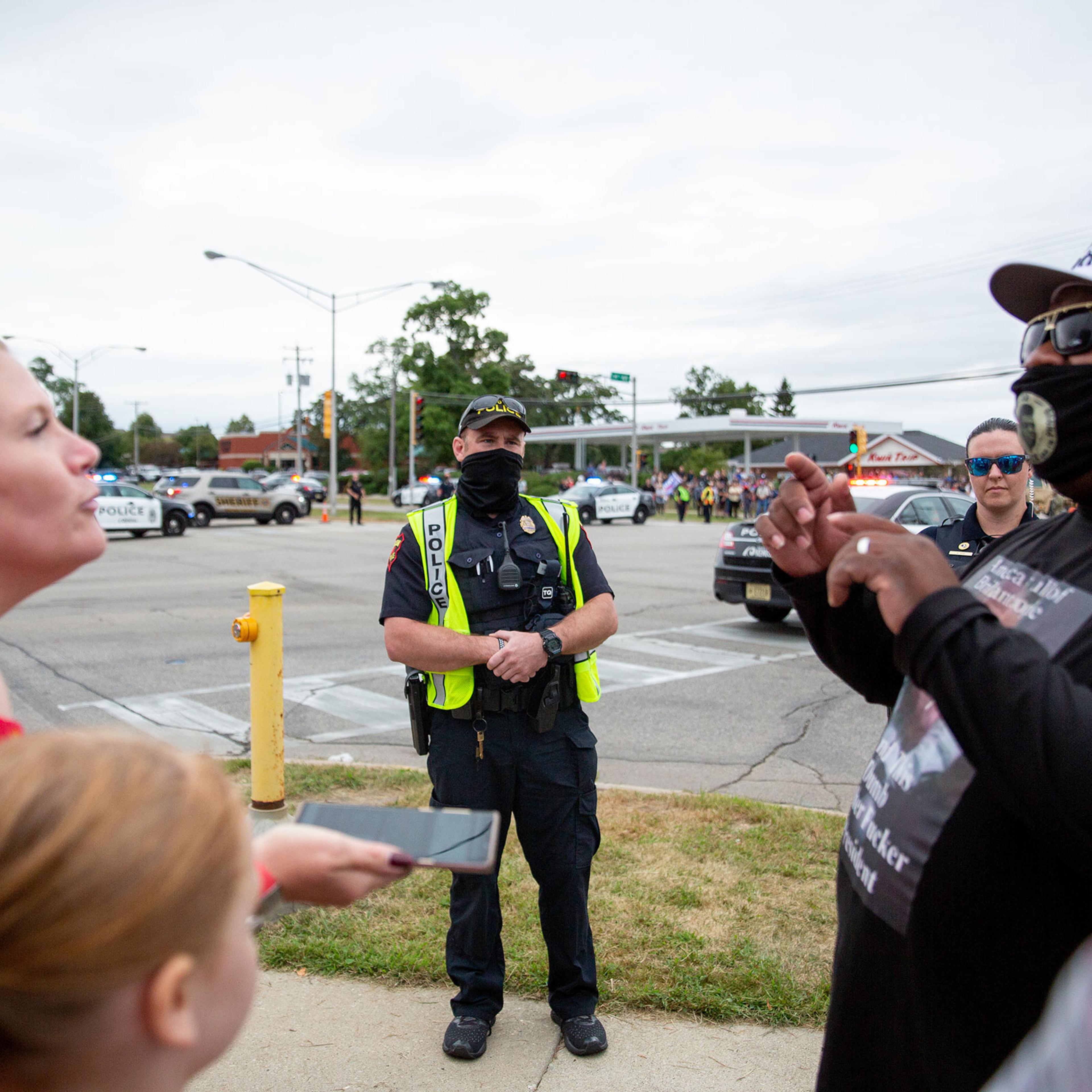 Police watch protestors during President Trump's meeting at Bradford High School in Kenosha, Wis., on Sept. 1, 2020.