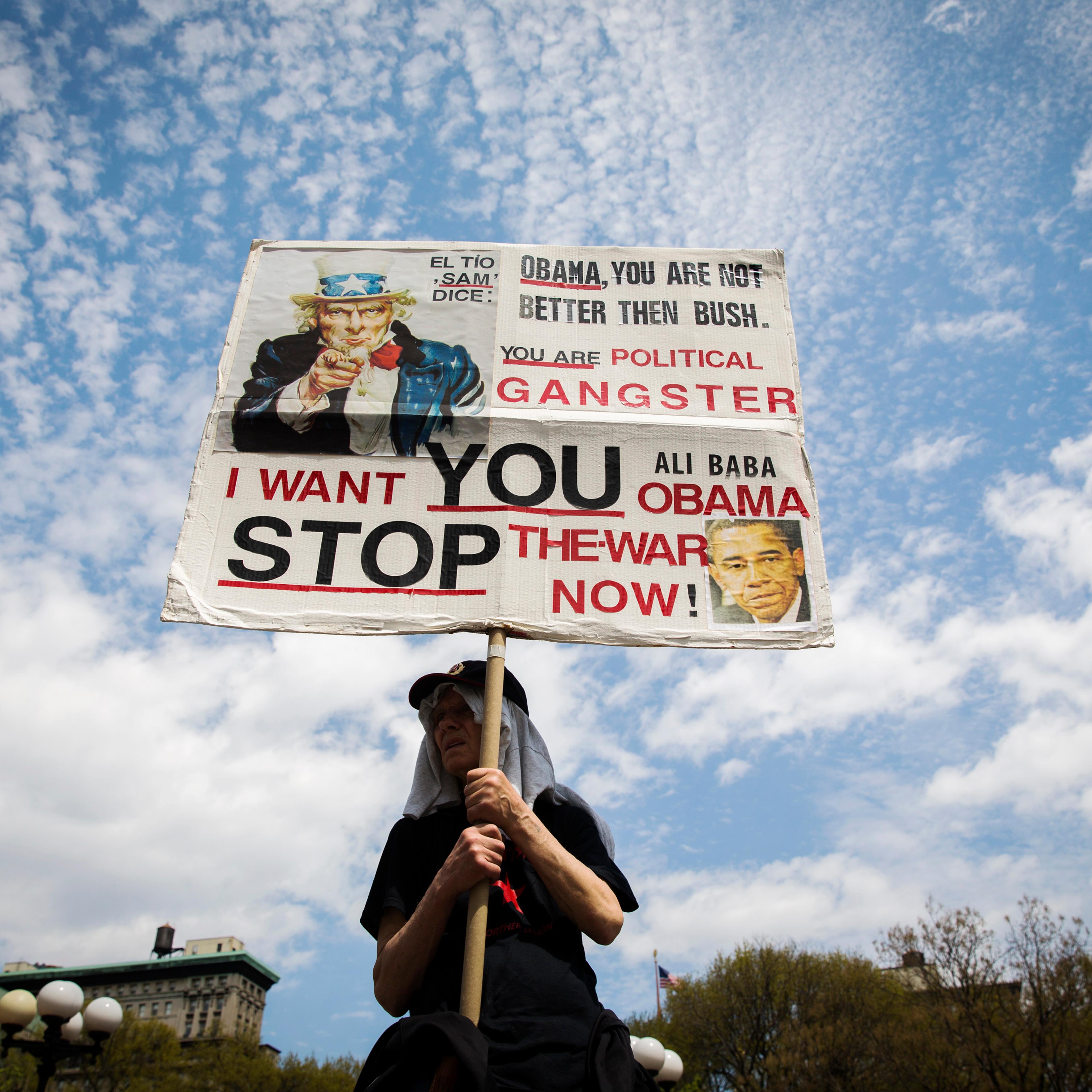 A demonstrator holds up a sign protesting the Obama administration's use of drones during May Day demonstrations in New York