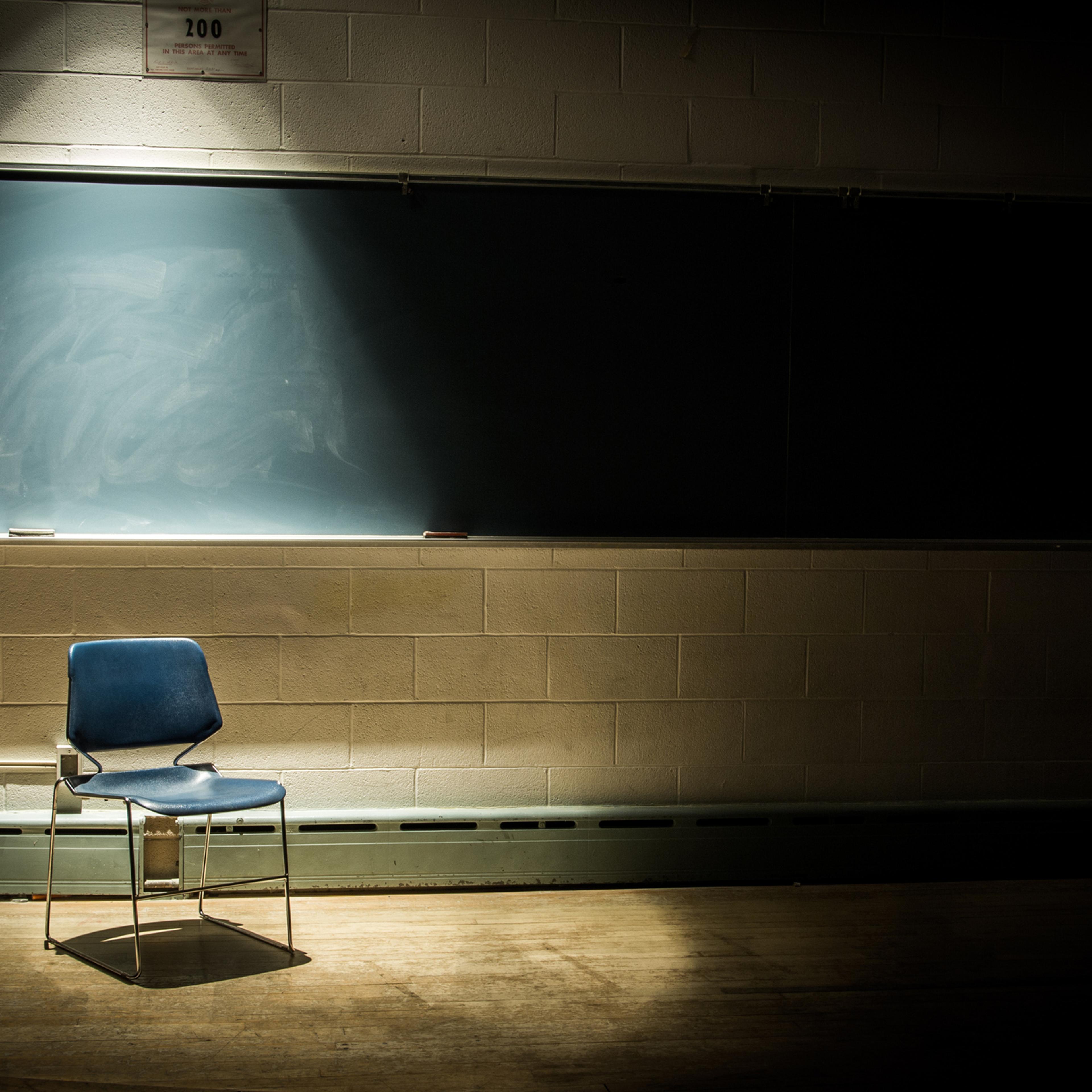 An Empty School Chair in a Dark Classroom