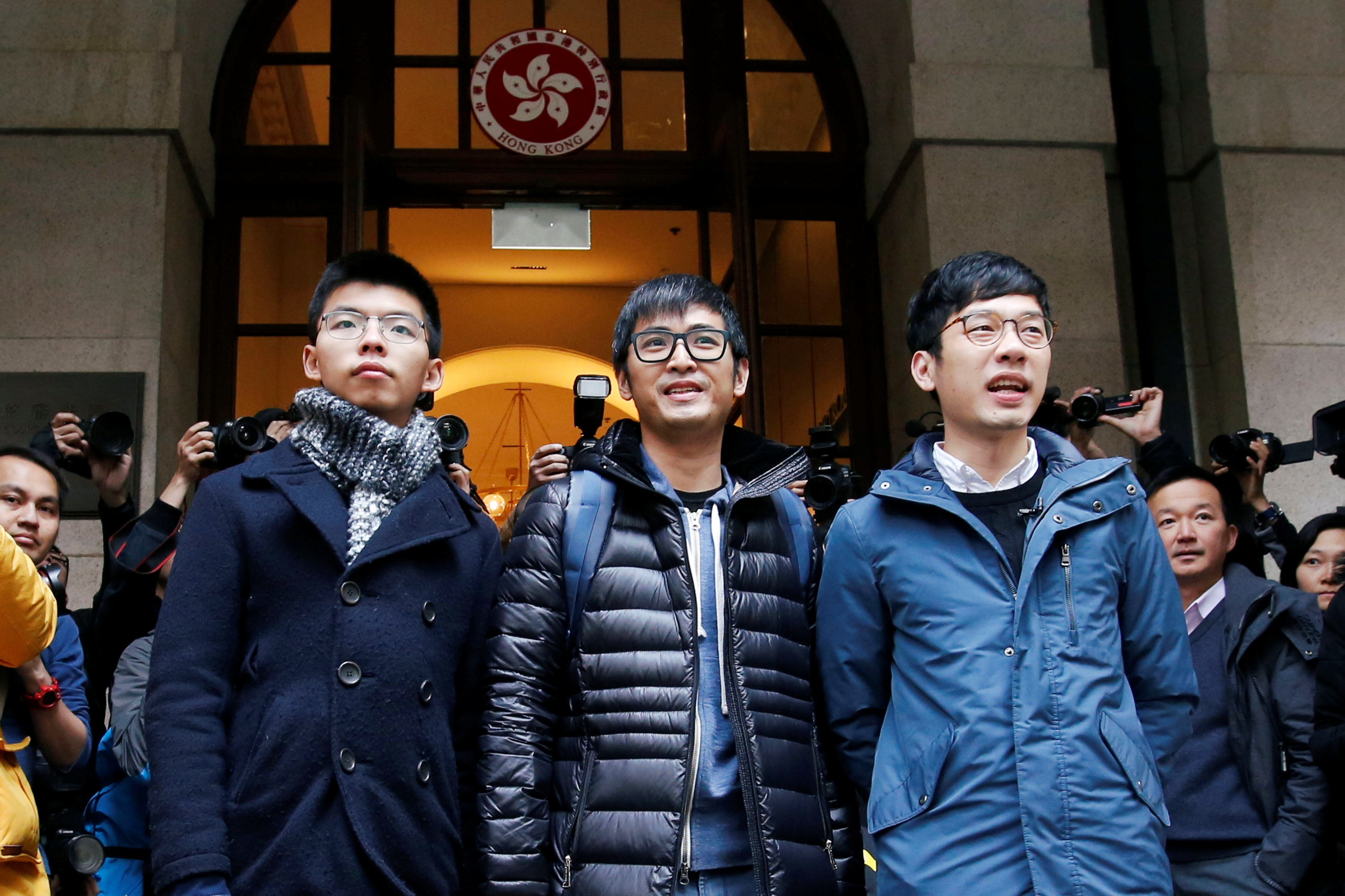 Pro-democracy activists Joshua Wong, Alex Chow and Nathan Law pose outside the Court of Final Appeal in Hong Kong