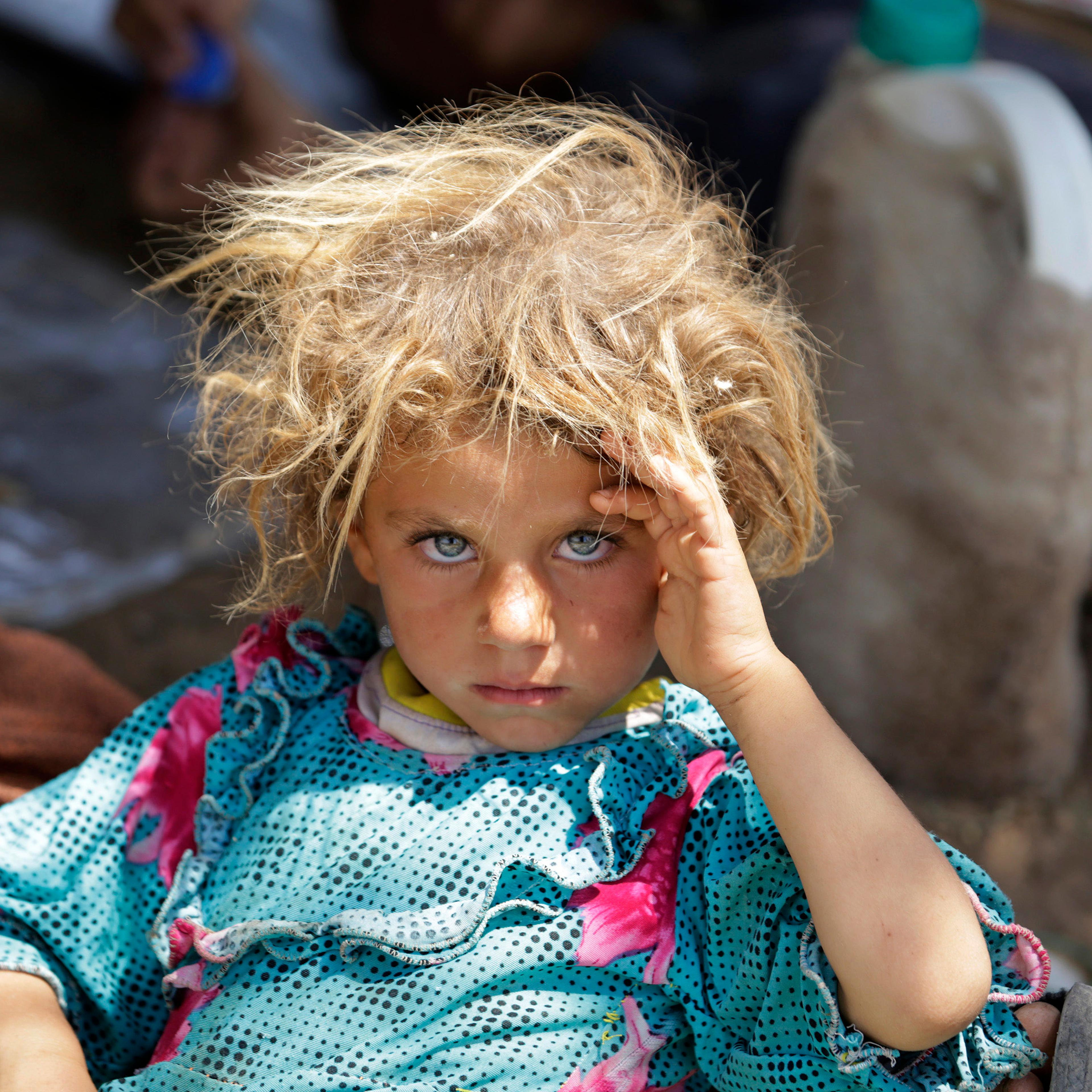 A girl from the minority Yazidi sect, fleeing the violence in the Iraqi town of Sinjar, rests at the Iraqi-Syrian border crossing in Fishkhabour