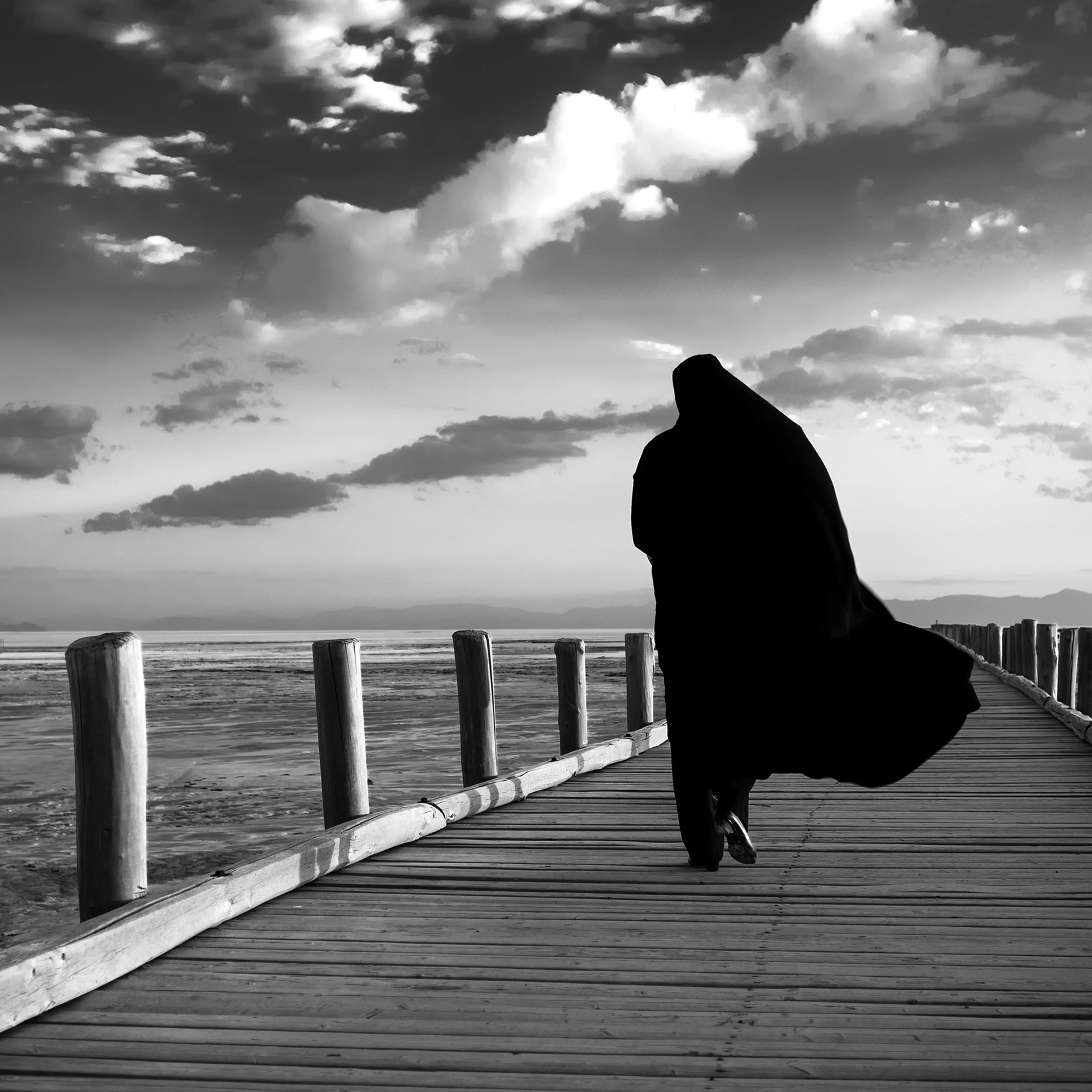 A woman walks on a wooden pier that once overlooked Lake Urmia's deep waters, July 2016, northwestern Iran. Since 1996, drought has contributed to the decline of the lake which now now covers only about 10 percent of the area it covered in the 1970s, Jul