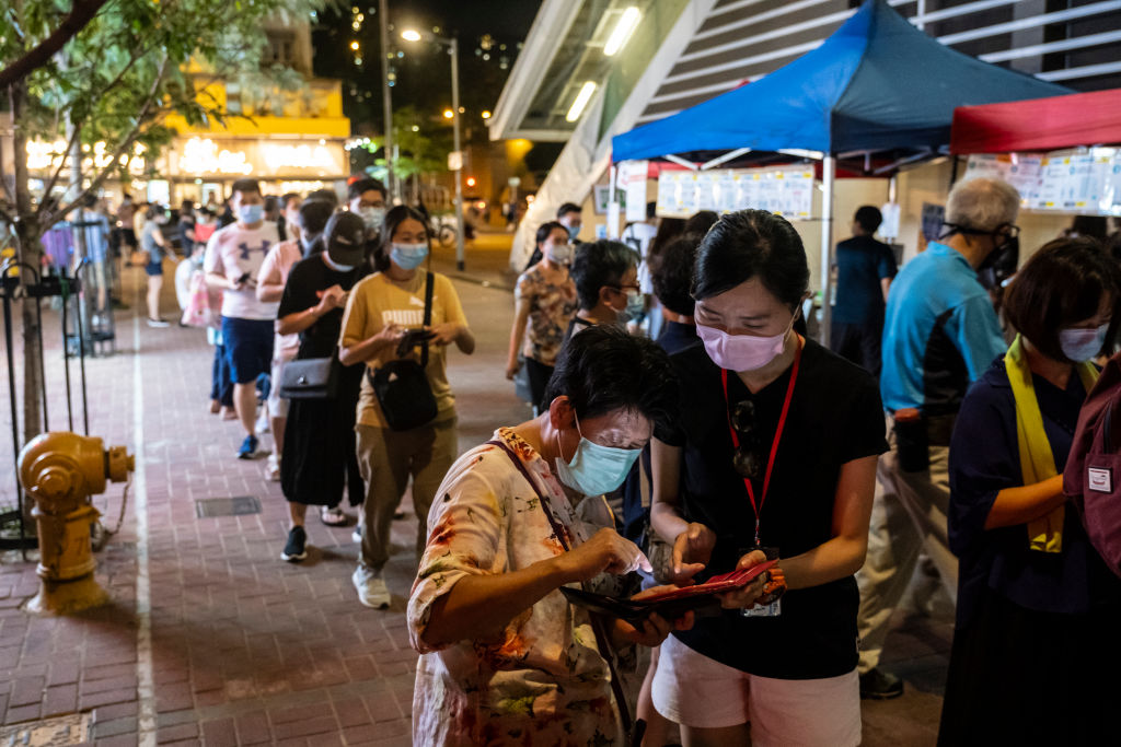A volunteer assists a voter at a temporary polling station