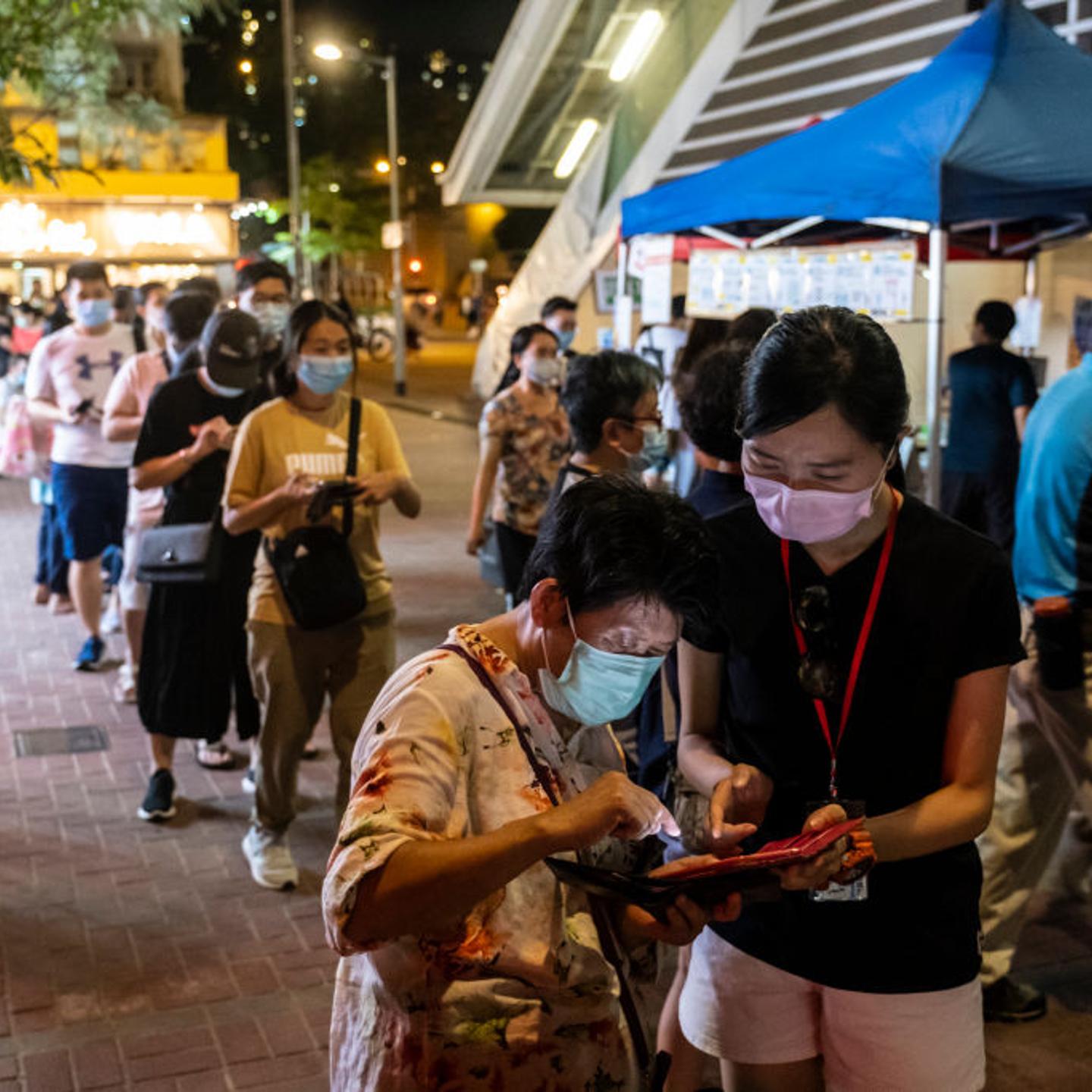 A volunteer assists a voter at a temporary polling station