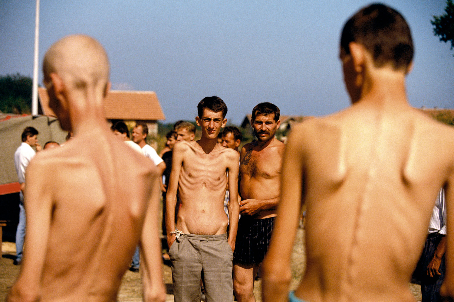 <b>August 1992. Trnopolje.</b><br><br>"When several journalists broke the story of the Serbian prison camps, there was a huge outcry in the world. Immediate comparisons to Nazi concentration camps were invoked and a demand for investigations and intervention were discussed. I was working on the Bosnian Serb side at the time trying to understand the war from their perspective as, like all wars, nothing is completely one-sided. However it was extremely difficult to work as it appeared the Bosnian Serbs didn't understand or care about journalism and the flow of information even when it was to help people understand them.<br><br>I asked a Bosnian Serb Army officer if I could go to a front line near where they had recently lost ground and show the effects on their civilian population. He quickly said no but said if I wanted I could go to visit the prison camps in order to see they really weren't as bad as people thought.<br><br>To this day I am not sure if the Bosnian Serb leadership made 