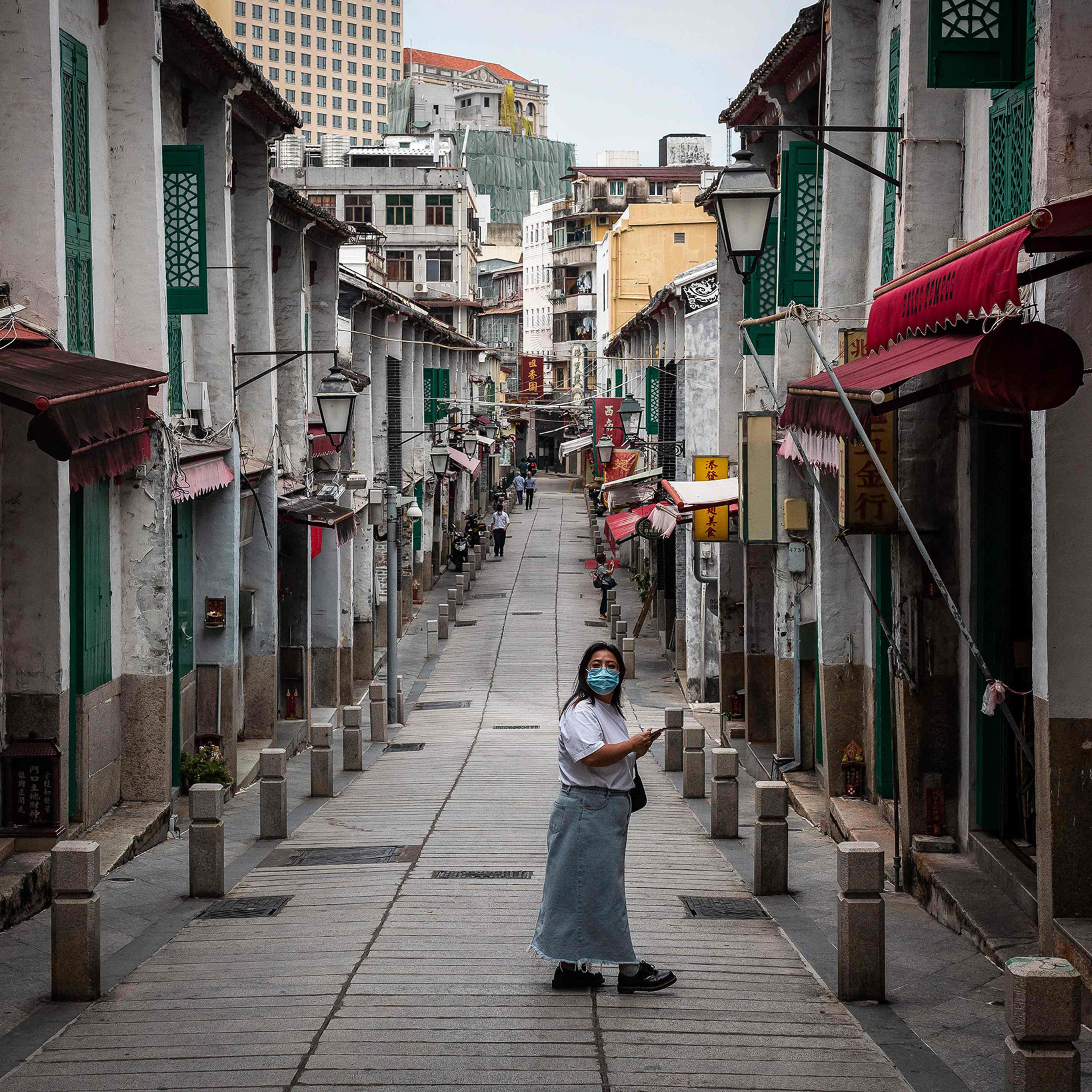 A pedestrian looks on as she walks in a street in the historical centre in Macau on Oct. 10.