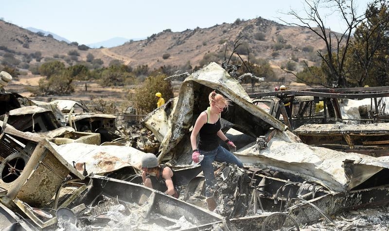 Emily Fryer, 20, searches for family heirlooms at her boyfriend's leveled home after the Erskine Fire burned through South Lake