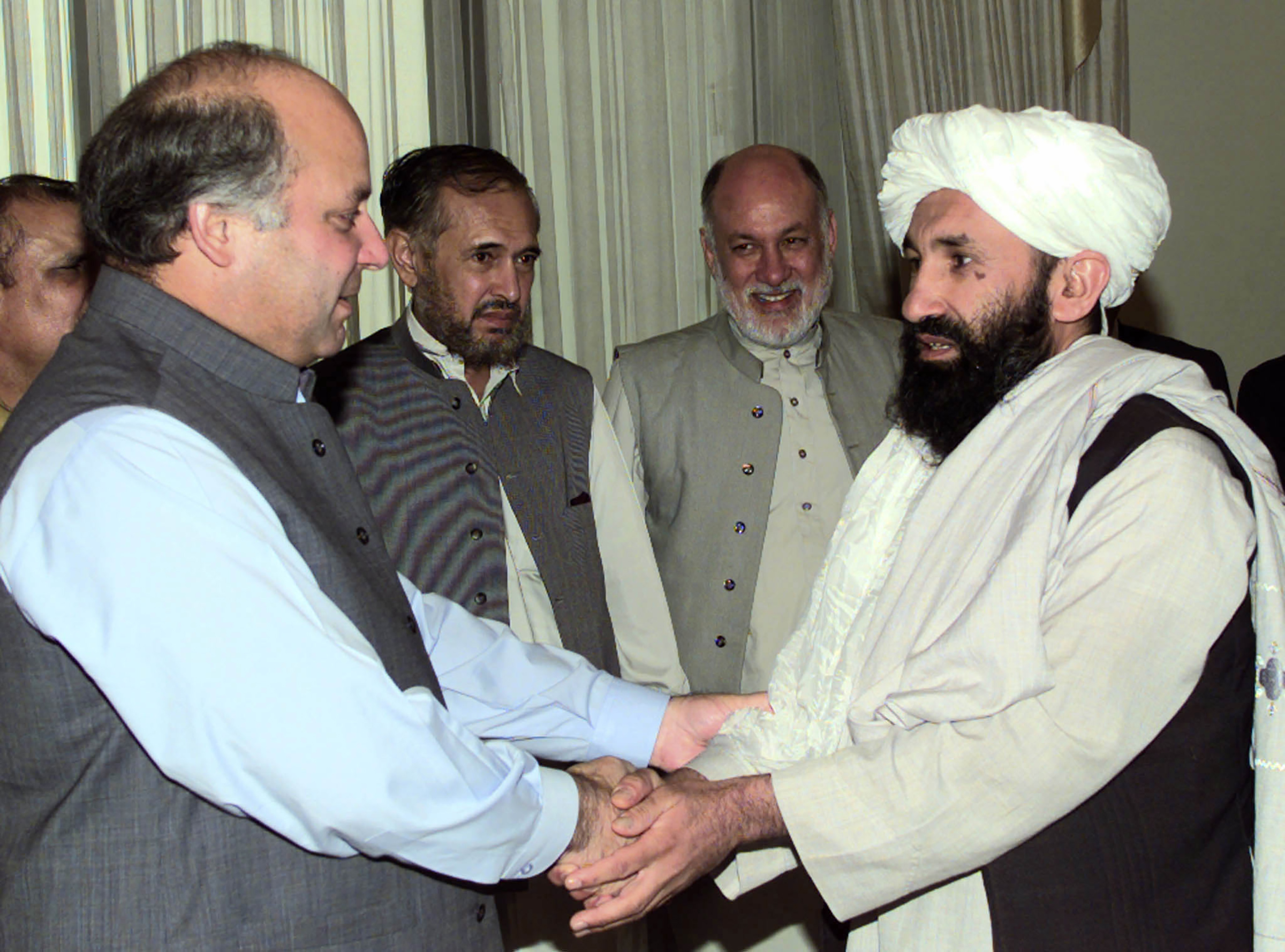 Afghan Foreign Minister Mullah Mohammad Hassan Akhund, right, is greeted by Pakistani Prime Minister Nawaz Sharif in Islamabad, Pakistan, on Aug. 25, 1999.