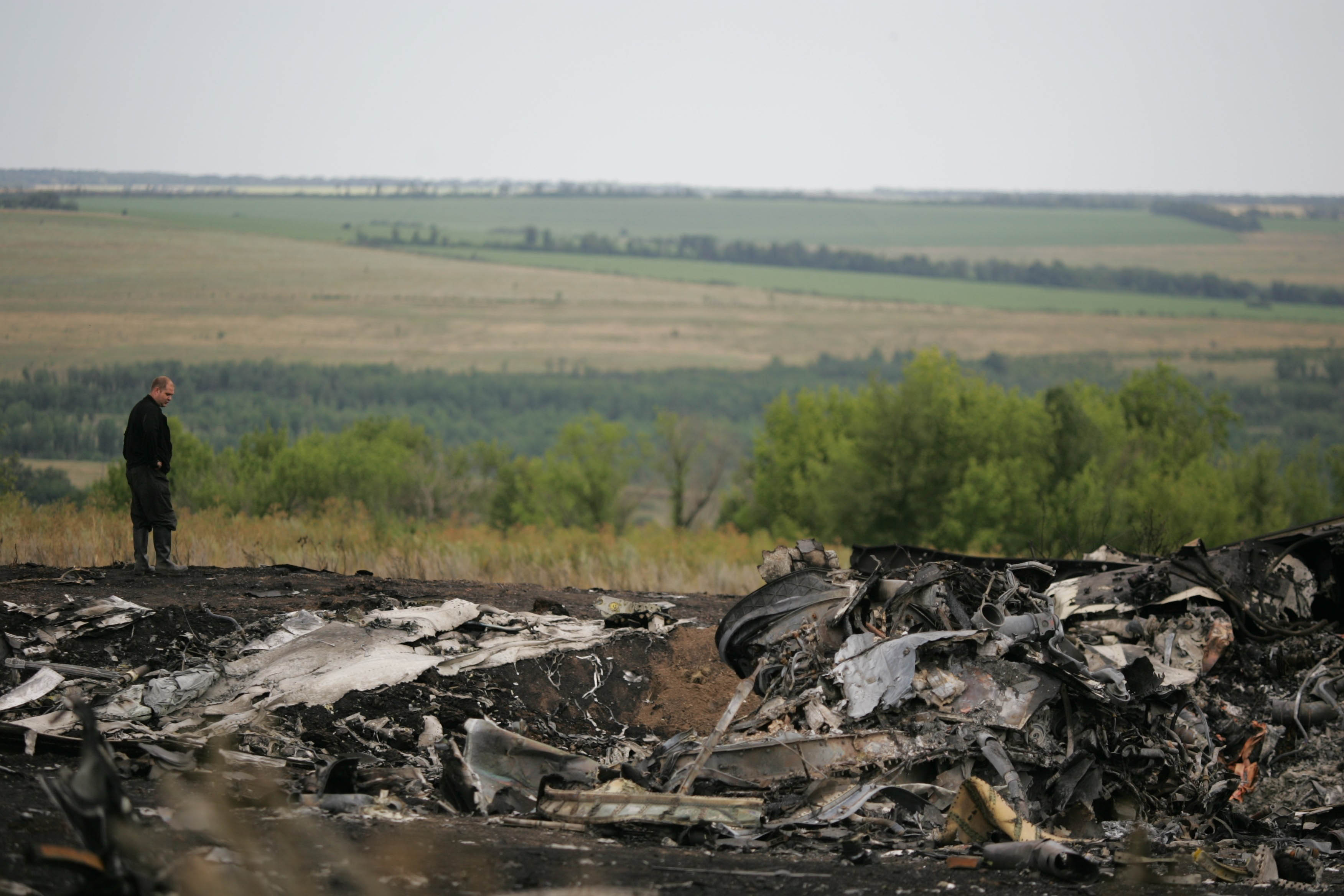 Experts inspect the wreckage of Malaysia Airlines plane