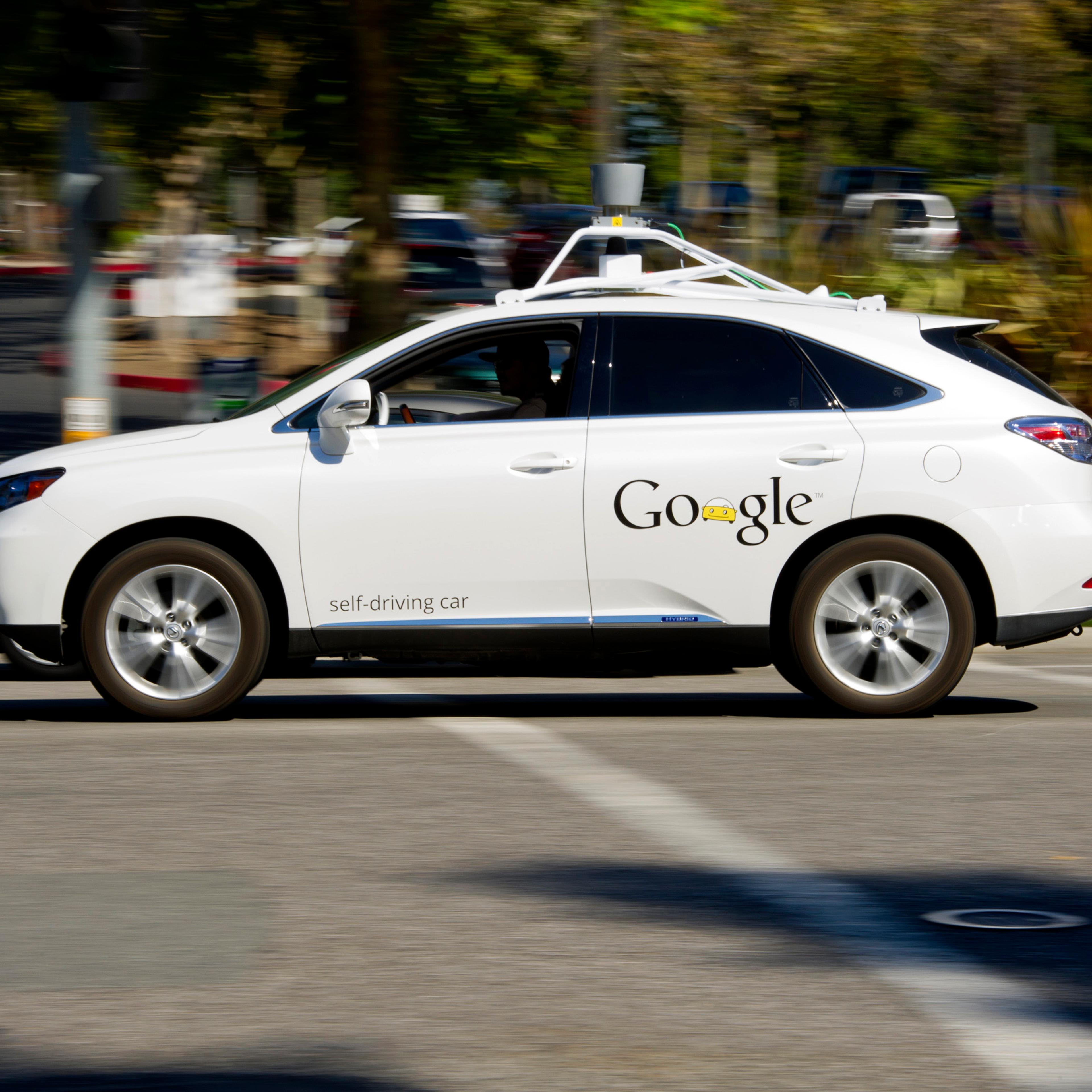 A driver drives a Google Inc. self-driving car in front of the company's headquarters in Mountain View, California on September 27, 2013.