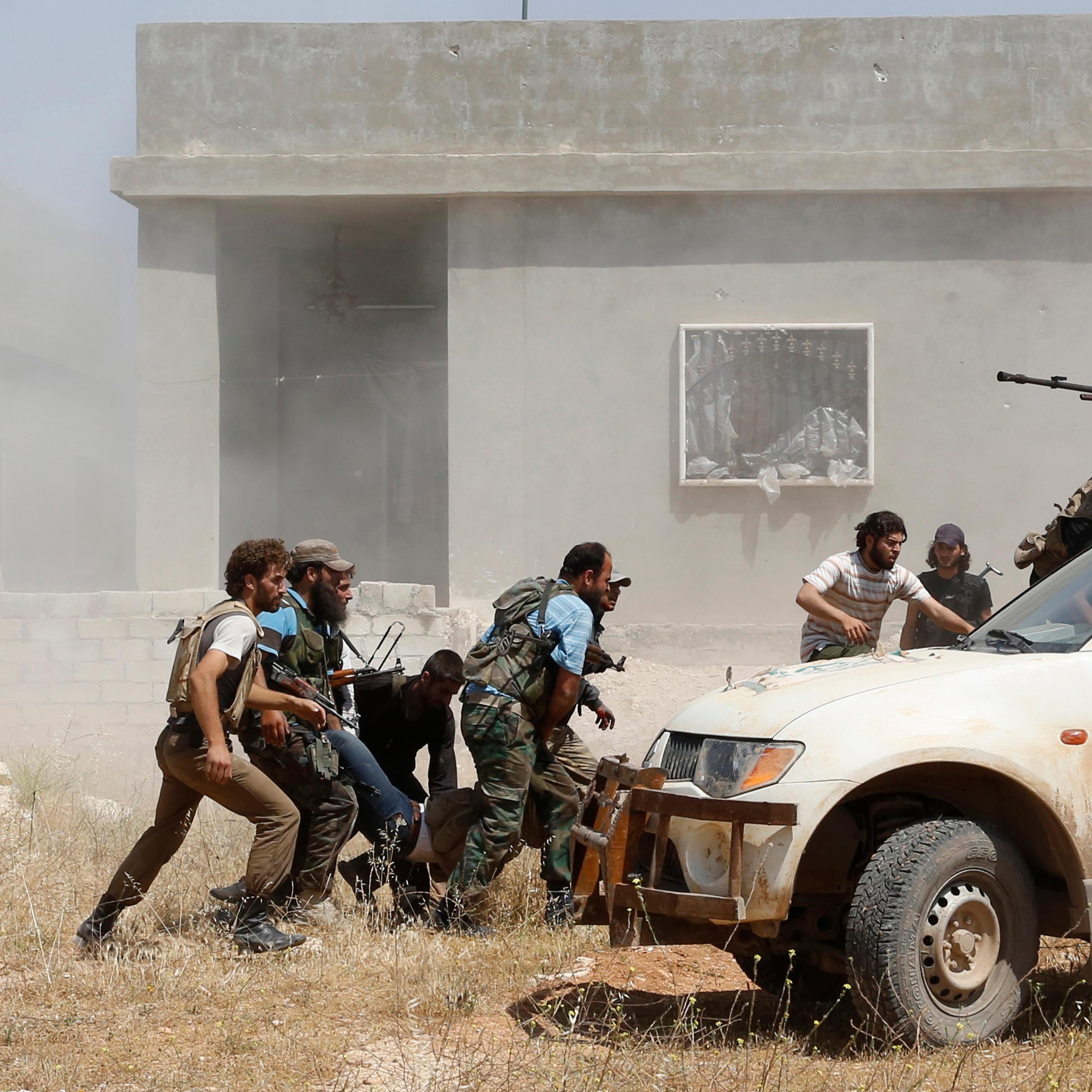 Free Syrian Army fighters help a fellow fighter wounded after what they said was clashes with forces loyal to Syria's President Bashar al-Assad, in Morek in Hama province