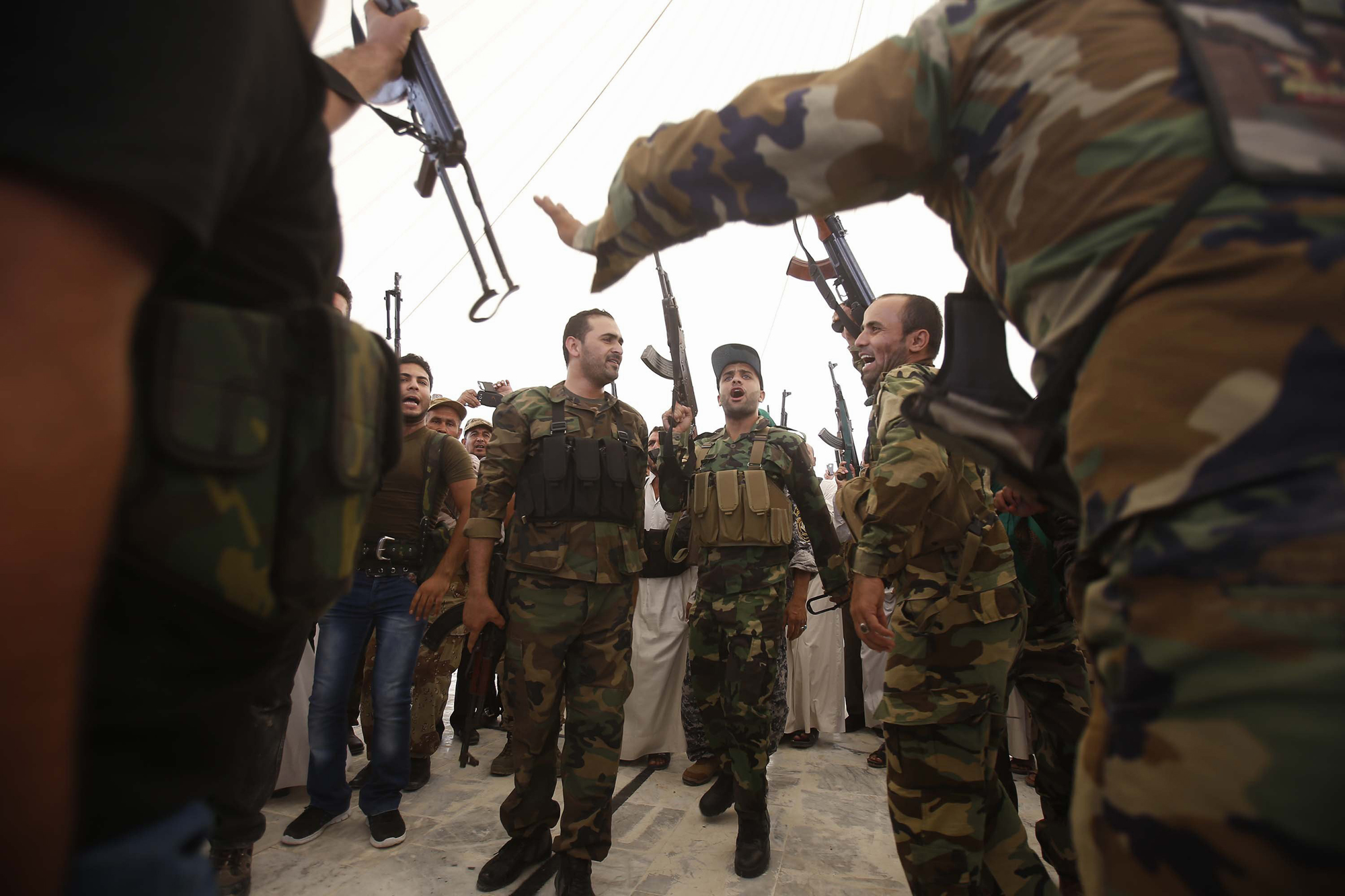 Iraqi Shiite men hold up their weapons during a training session in the shrine city of Karbala, in central Iraq, on June 25, 2014 after they volunteered to protect the Shiite holy sites in central and south Iraq in case of an attack by Sunni militants le