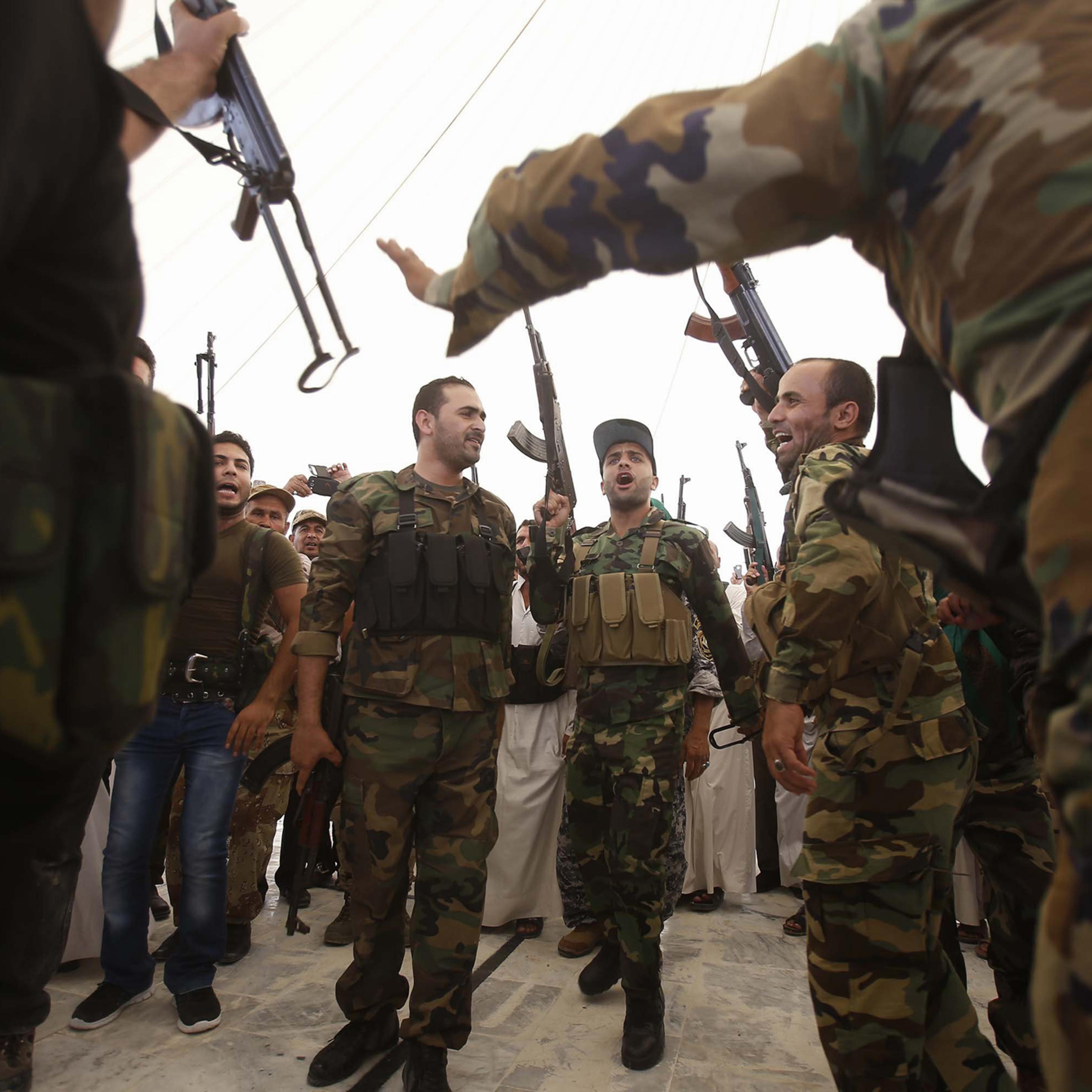 Iraqi Shiite men hold up their weapons during a training session in the shrine city of Karbala, in central Iraq, on June 25, 2014 after they volunteered to protect the Shiite holy sites in central and south Iraq in case of an attack by Sunni militants le