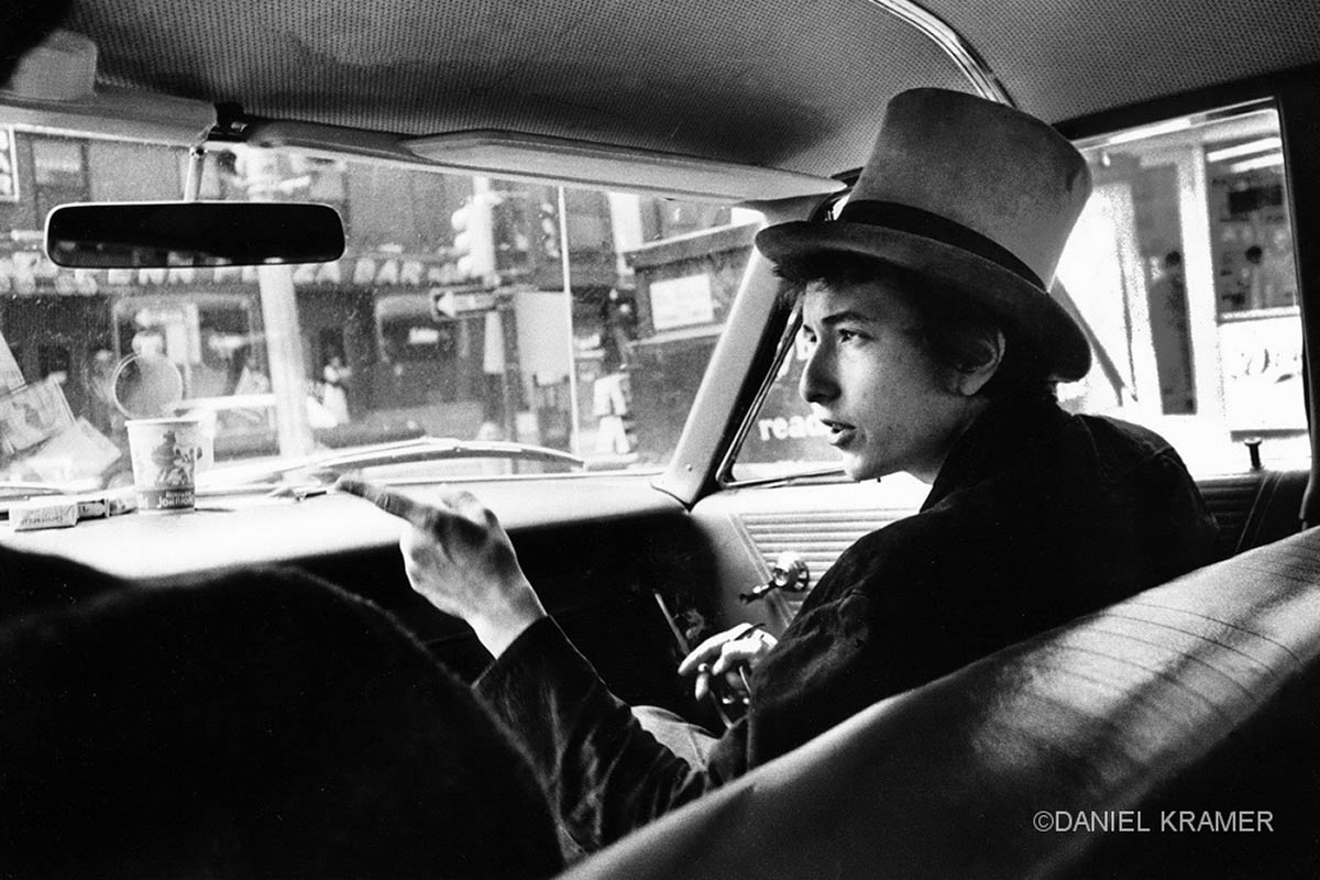 Bob Dylan with top hat pointing in car, Philadelphia, Pa.,1964.
