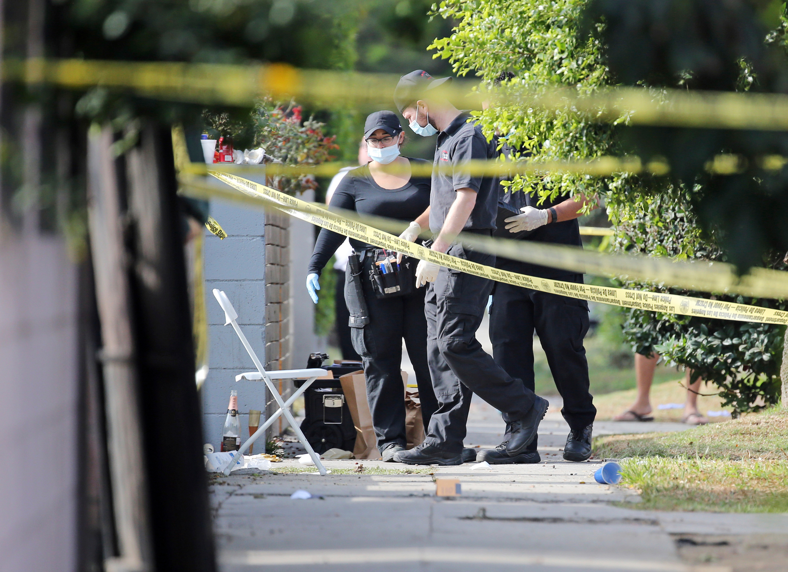 Los Angeles police investigators work the scene of a fatal shooting in the Crenshaw District neighborhood of Los Angeles, Saturday, Oct. 15, 2016. According to police an early morning argument at a restaurant triggered gunfire. (AP Photo/Reed Saxon)