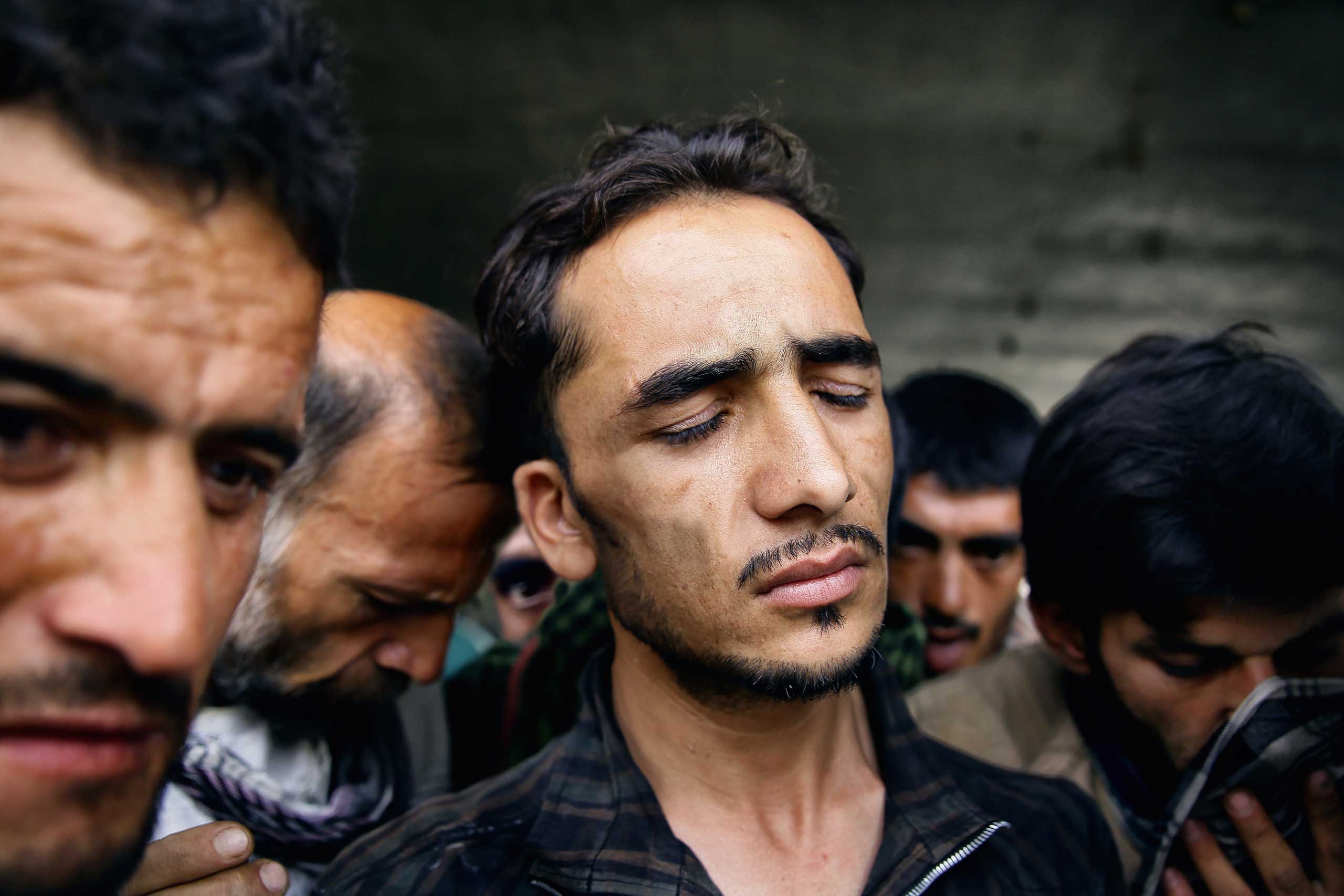 Abdul Rahim Qadl grimaces in a haze after smoking a hit of opium resin under Pul-e Sukhta bridge, Kabul on Aug. 1, 2014.