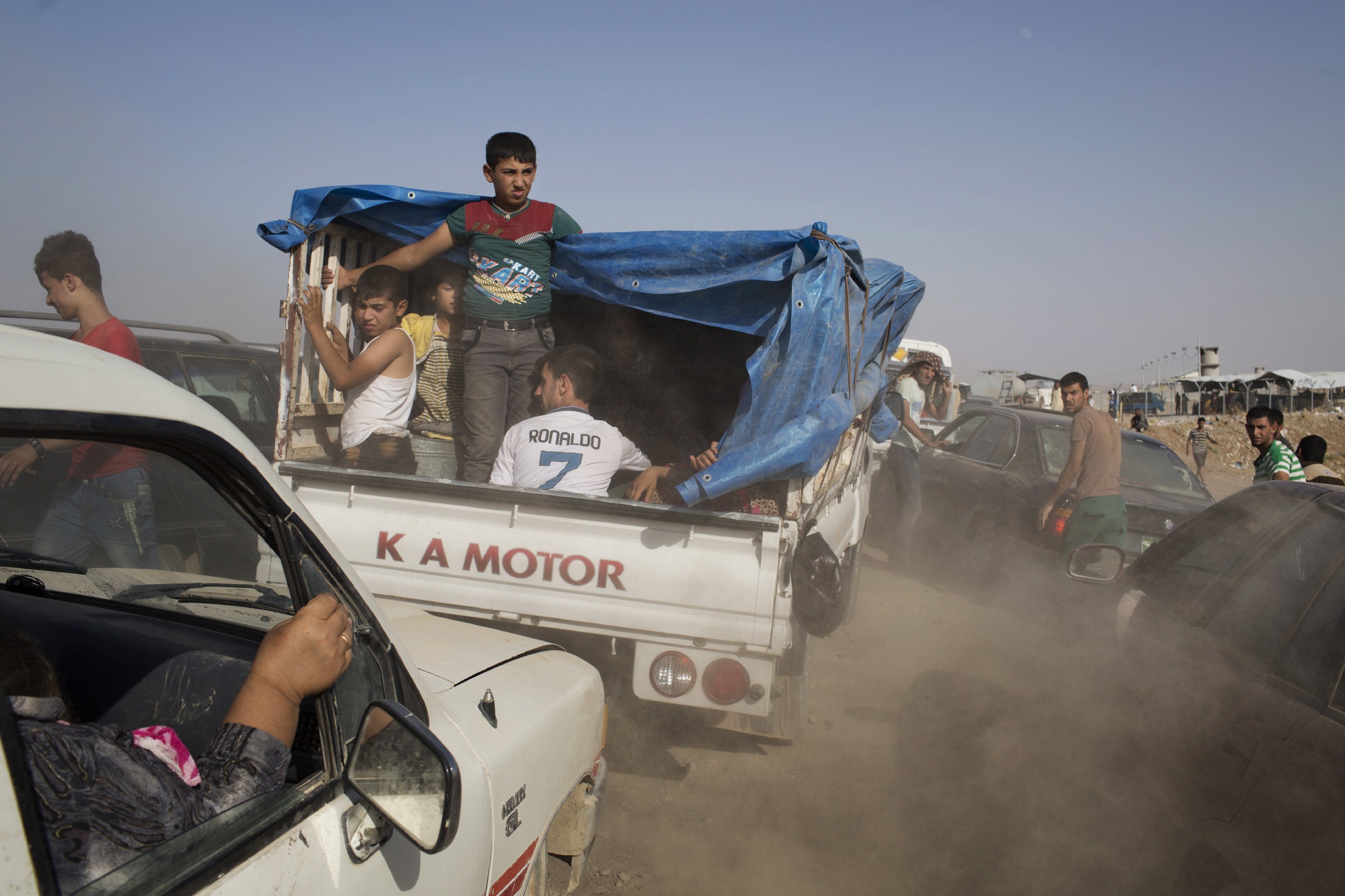 Iraqis arrive at a peshmerga controlled checkpoint between Irbil and Mosul after fleeing villages near Mosul in fear of Islamic State of Iraq and the Levant attacks.