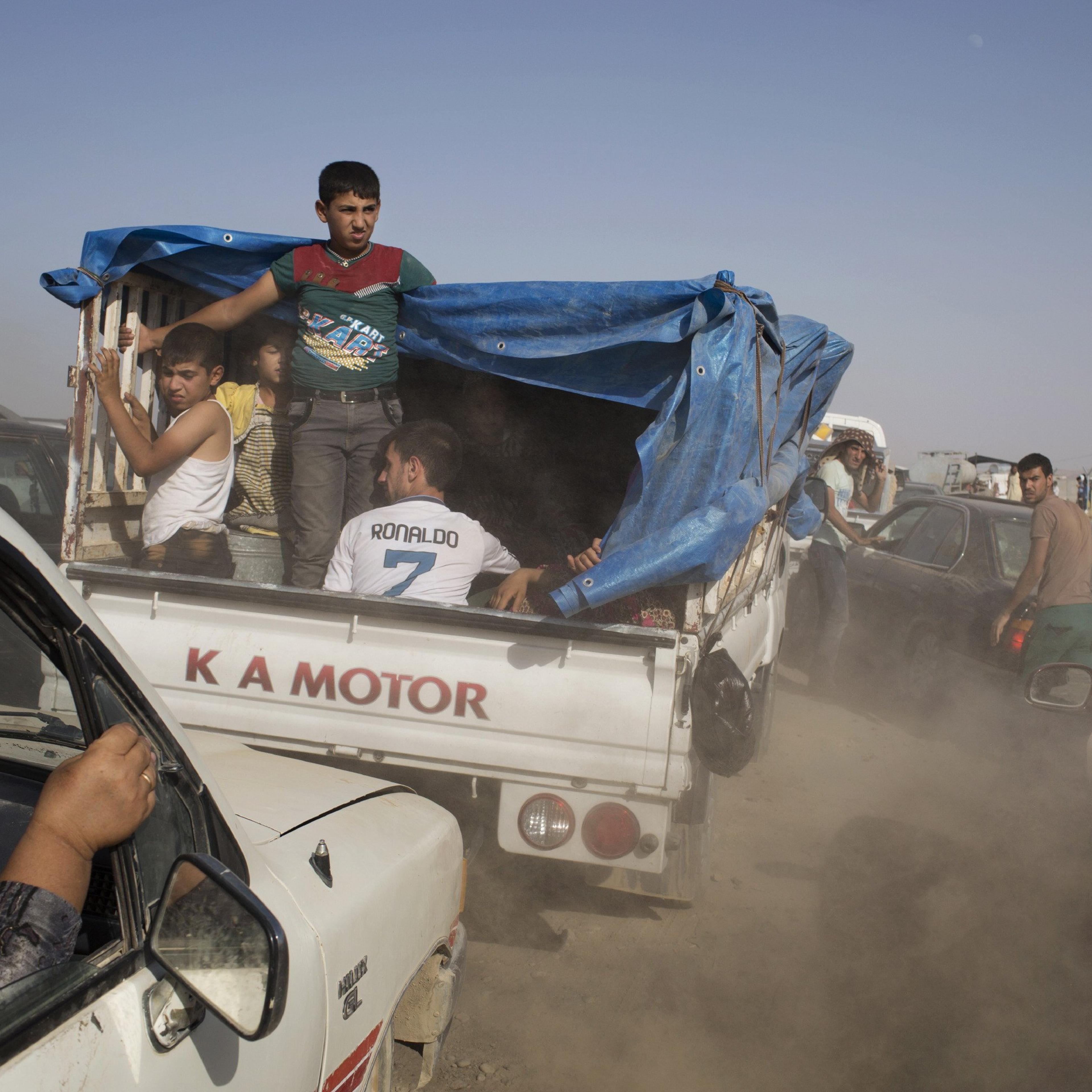 Iraqis arrive at a peshmerga controlled checkpoint between Irbil and Mosul after fleeing villages near Mosul in fear of Islamic State of Iraq and the Levant attacks.