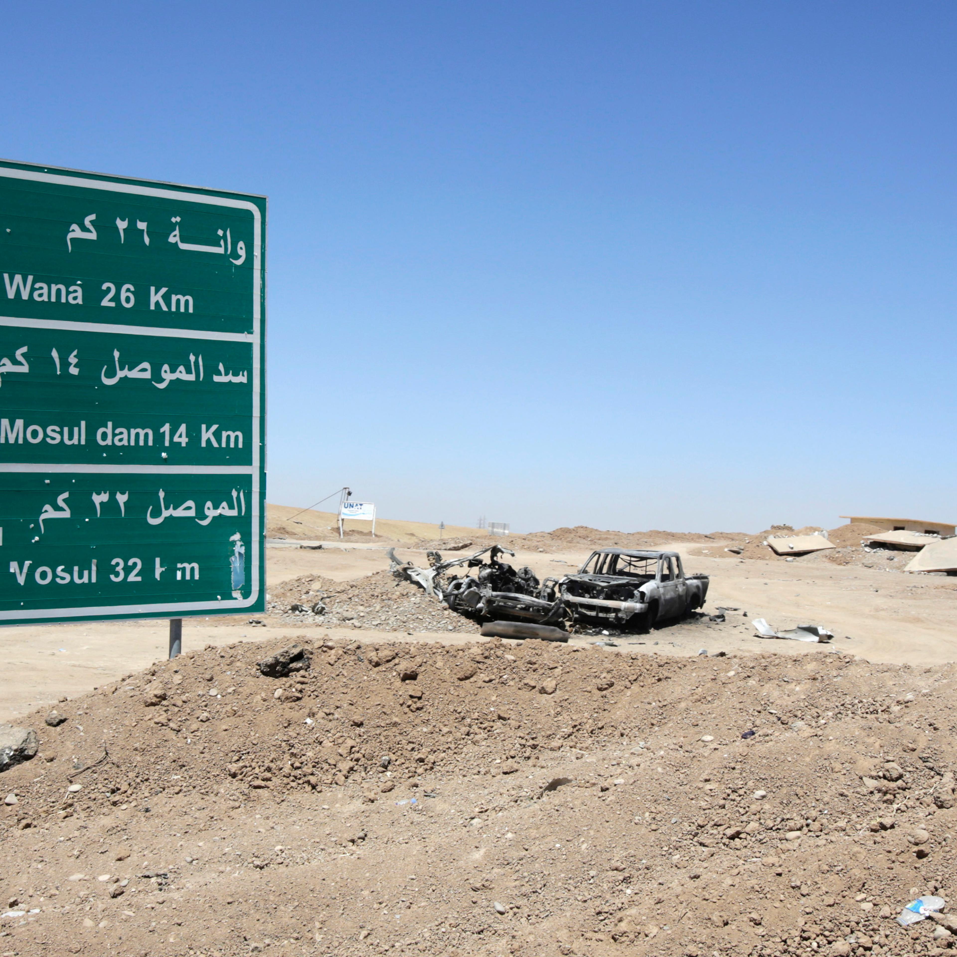 The wreckage of a car belonging to Islamic State militants lies along a road after it was targeted by a U.S. air strike at the entrance to the Mosul Dam