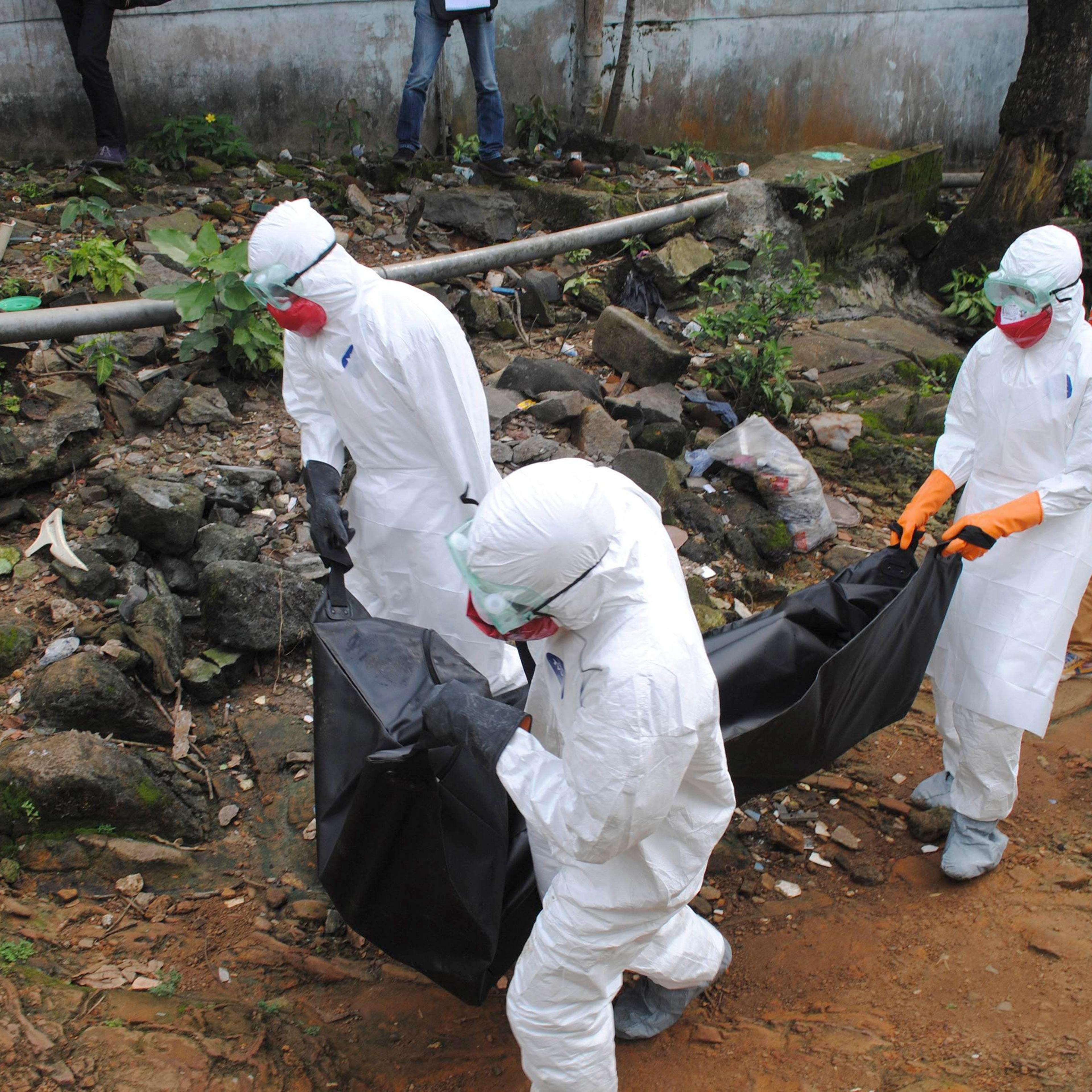 Health workers remove the body of Prince Nyentee, a man whom local residents said died of Ebola virus in Monrovia