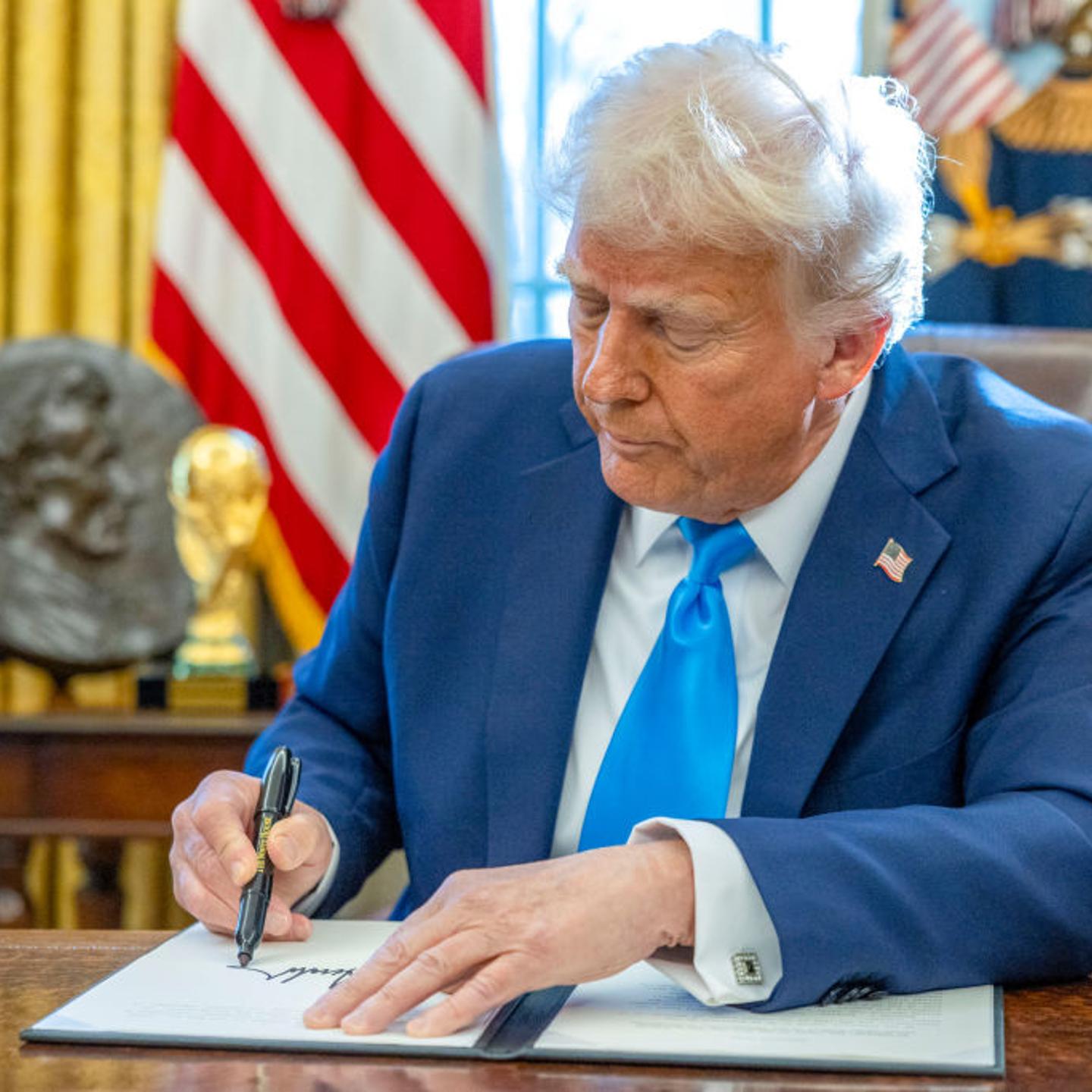 US President Donald Trump signs an executive order in the Oval Office of the White House in Washington, DC, US, on Feb. 4, 2025.