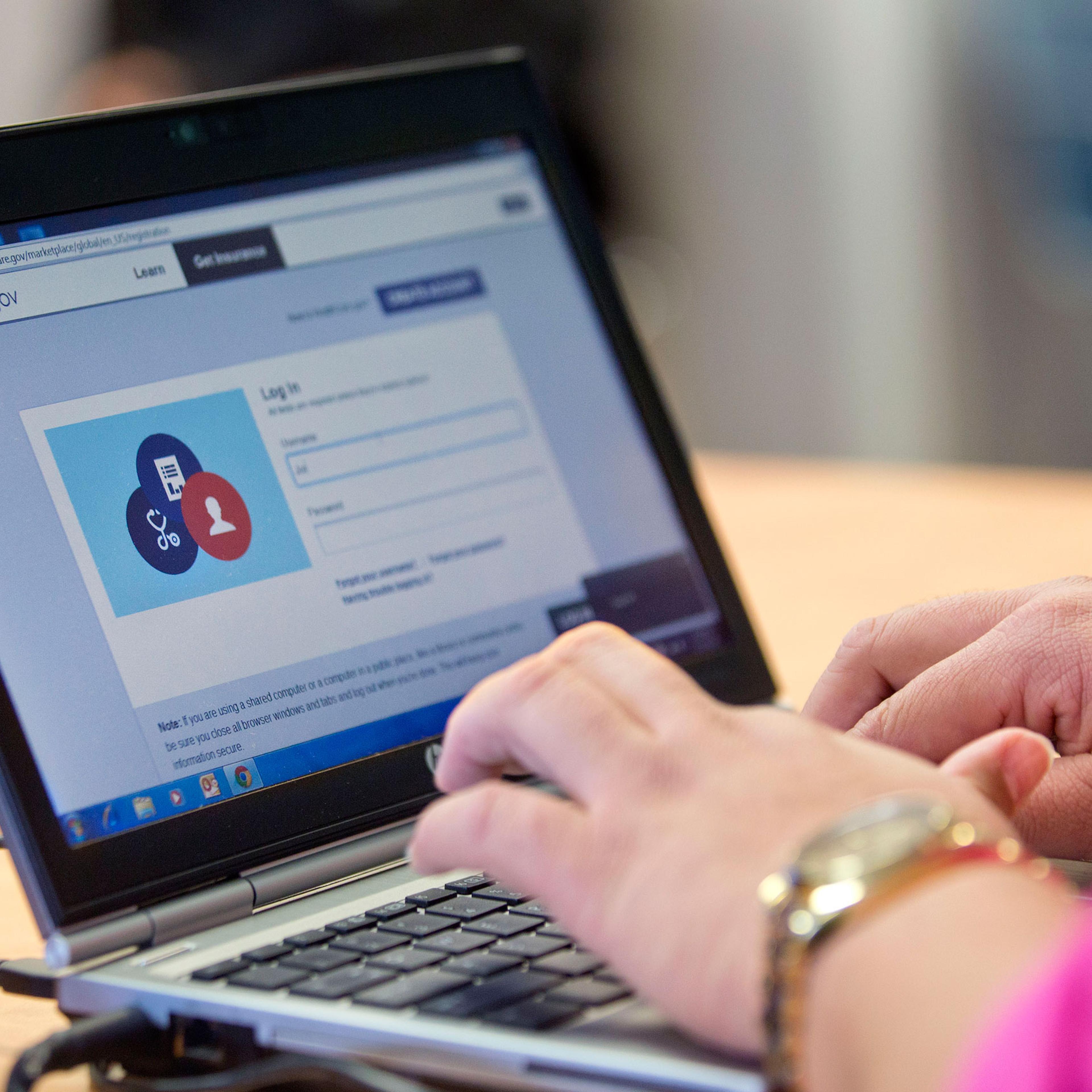 Marketplace guide Stephanie Cantres works on the Healthcare.gov federal enrollment website to help a resident sign up for a health insurance plan under the Affordable Care Act at a Westside Family Healthcare center enrollment event in Bear, Delaware, on