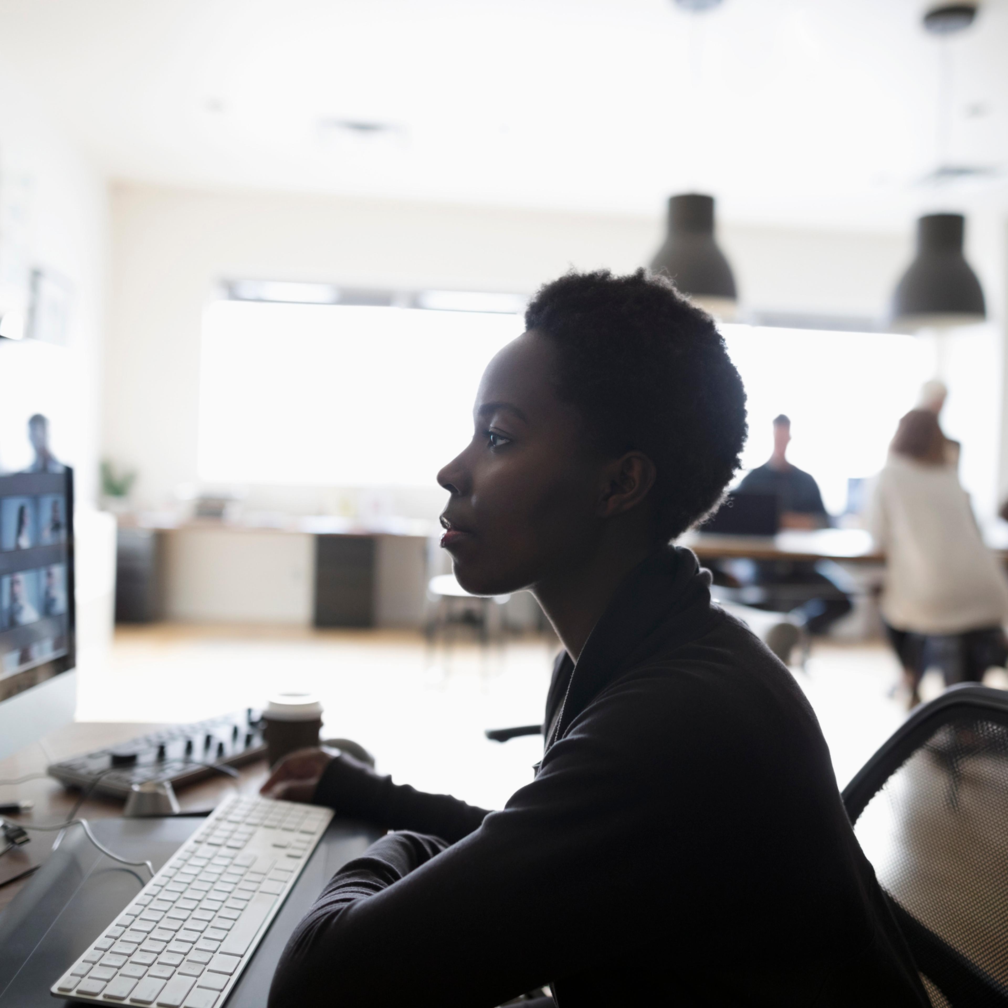 Female photo editor reviewing digital photo proofs on computer in office