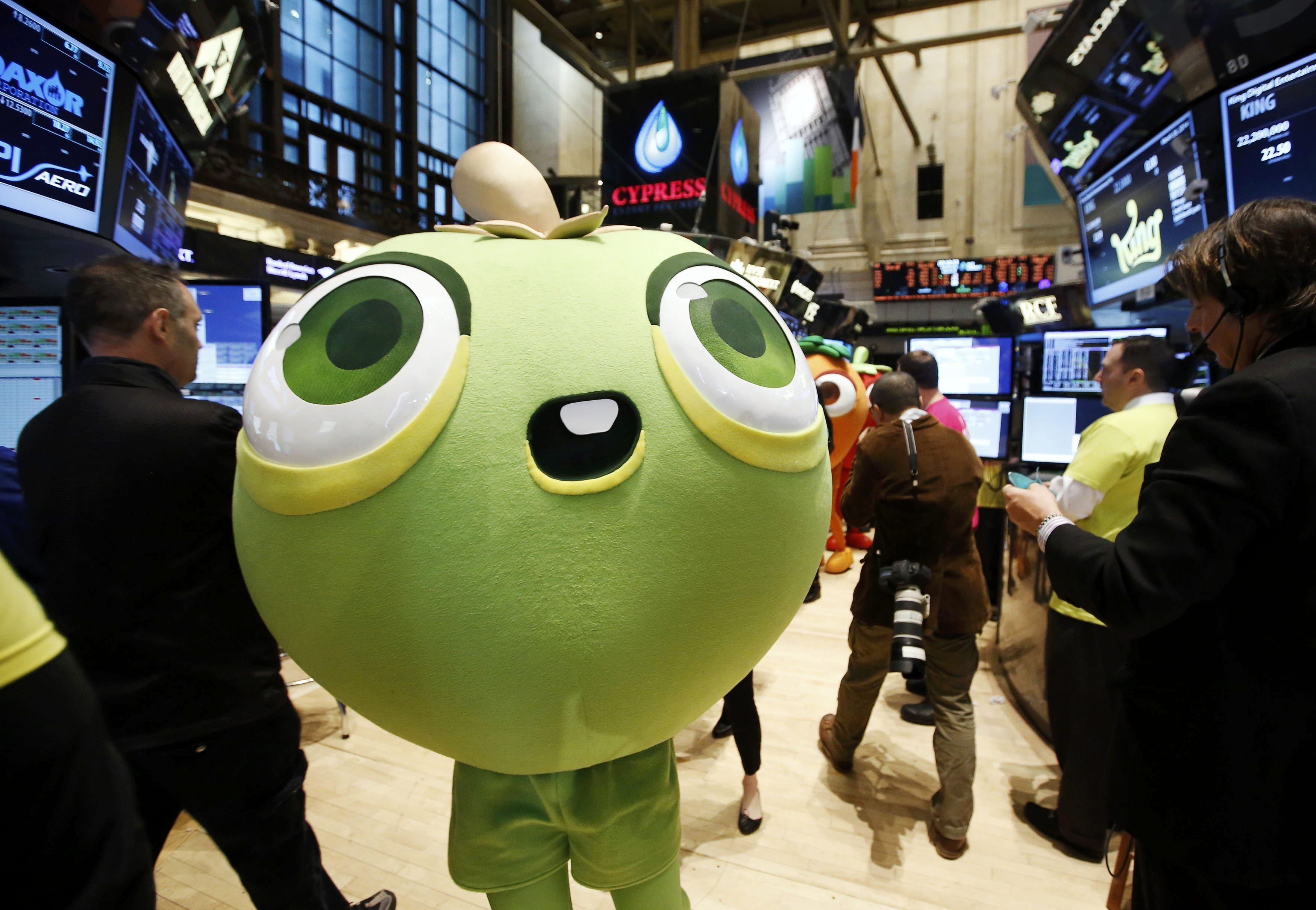A mascot dressed as a character from the mobile game "Candy Crush Saga" walks the floor of the New York Stock Exchange during the IPO of Mobile game maker King Digital Entertainment Plc