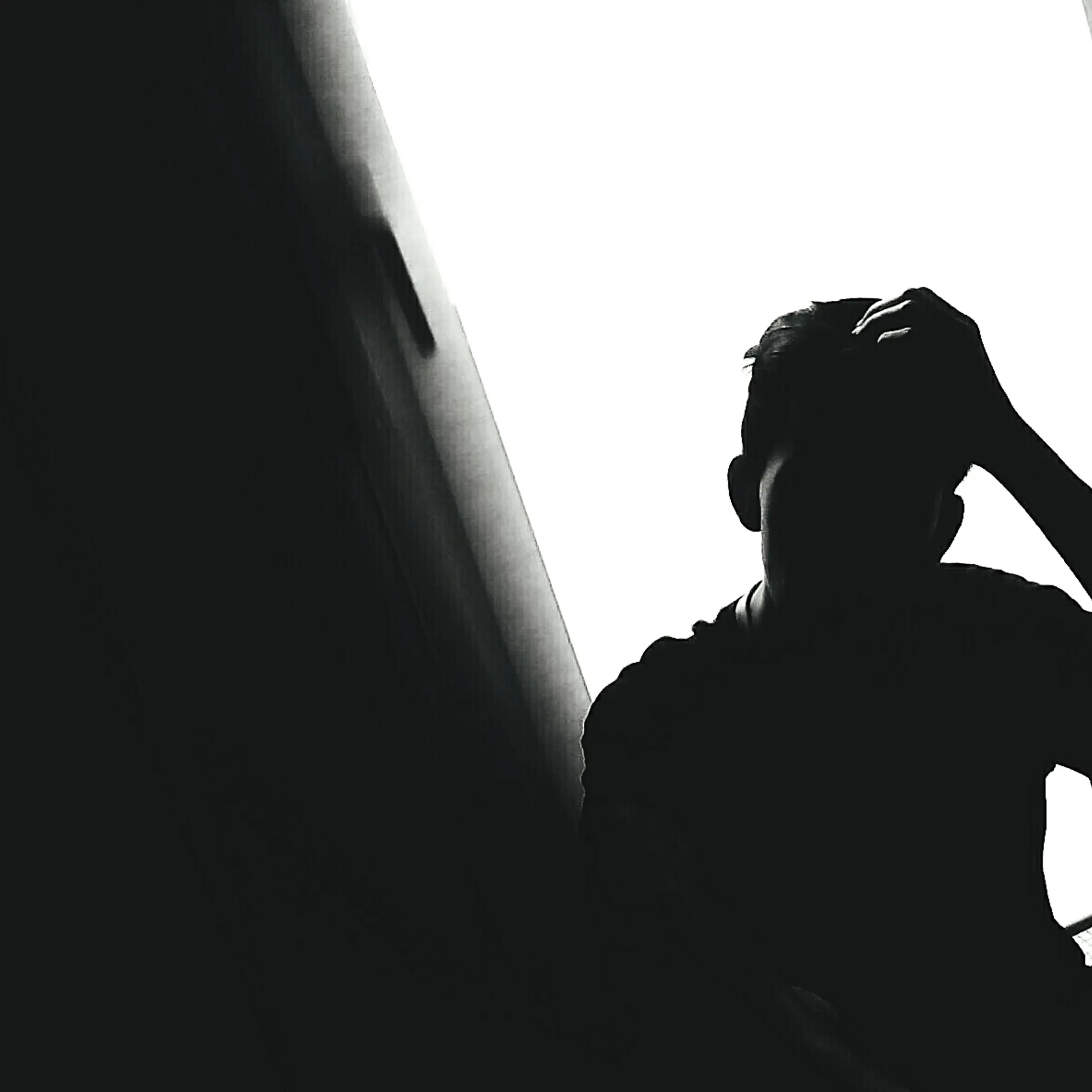 Silhouette Of Disappointed Man With His Head In Hands