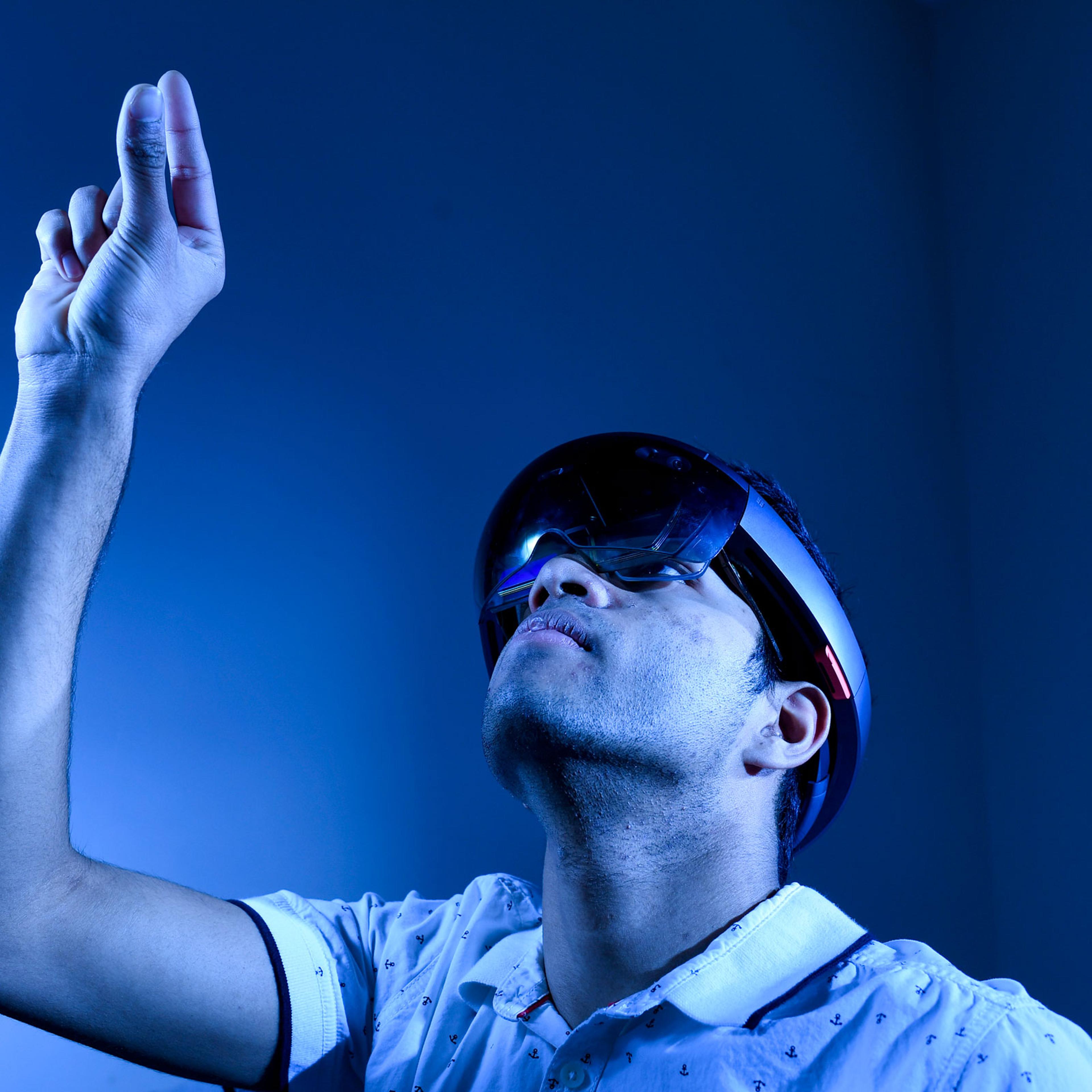 Krithik Ramesh, winner of the Intel International Science and Engineering Fair posing for a photo in his home, while using his program that overlays a 3d skeletal diagram over patients and can by controlled with hand movement