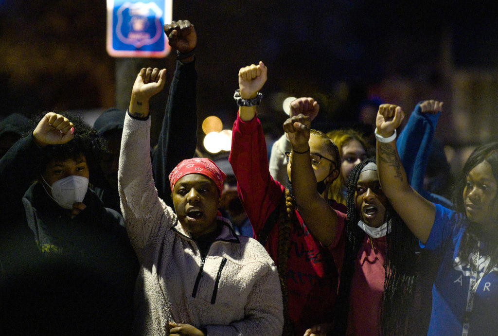 Demonstrators chant around a chalk circle that says Justice for Daunte Wright on April 11, 2021 in Brooklyn Center, Minnesota