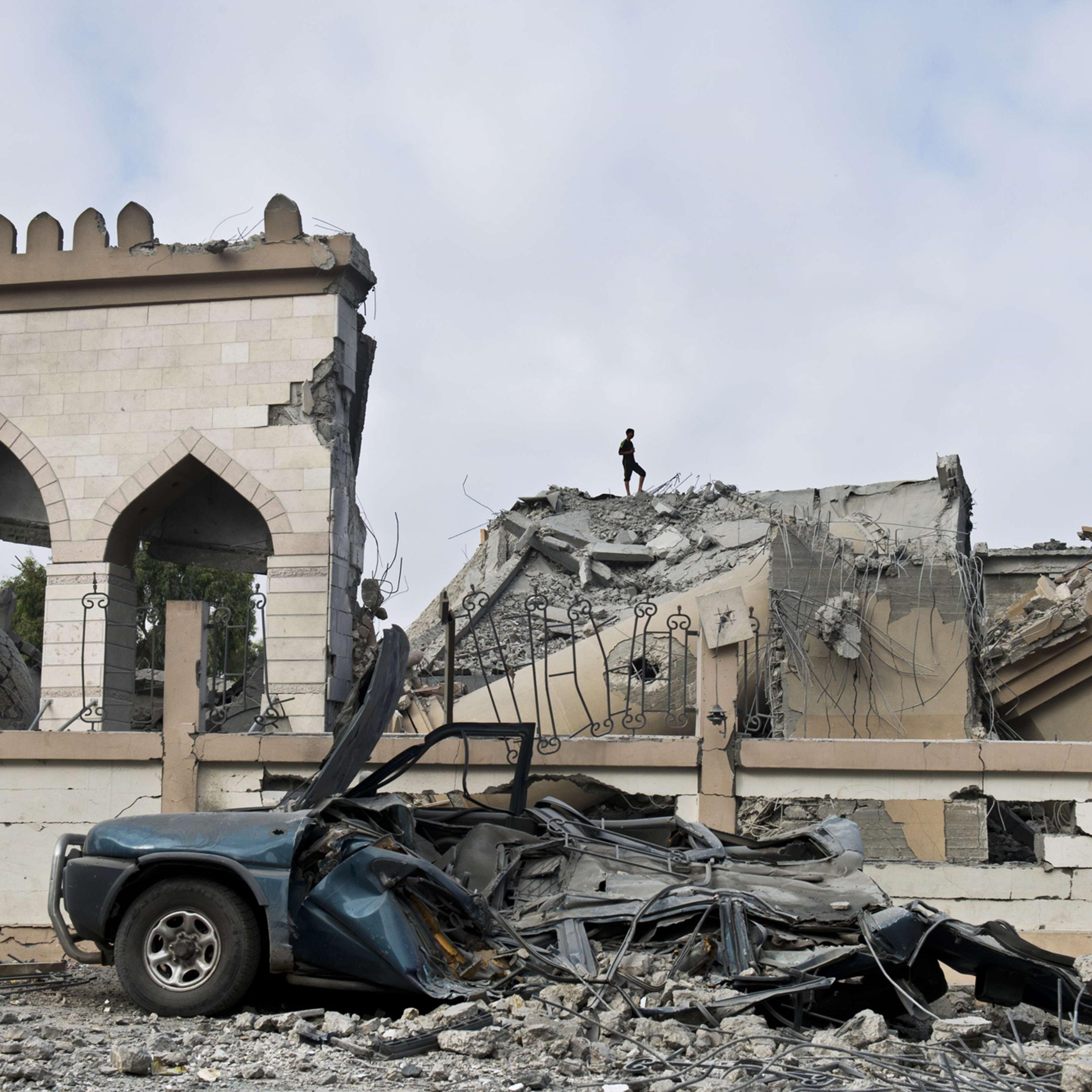 A Palestinian walks on the rubble of a mosque that was partially damaged by an airstrike on Aug. 25, 2014 in Beit Lahia in the northern Gaza Strip.