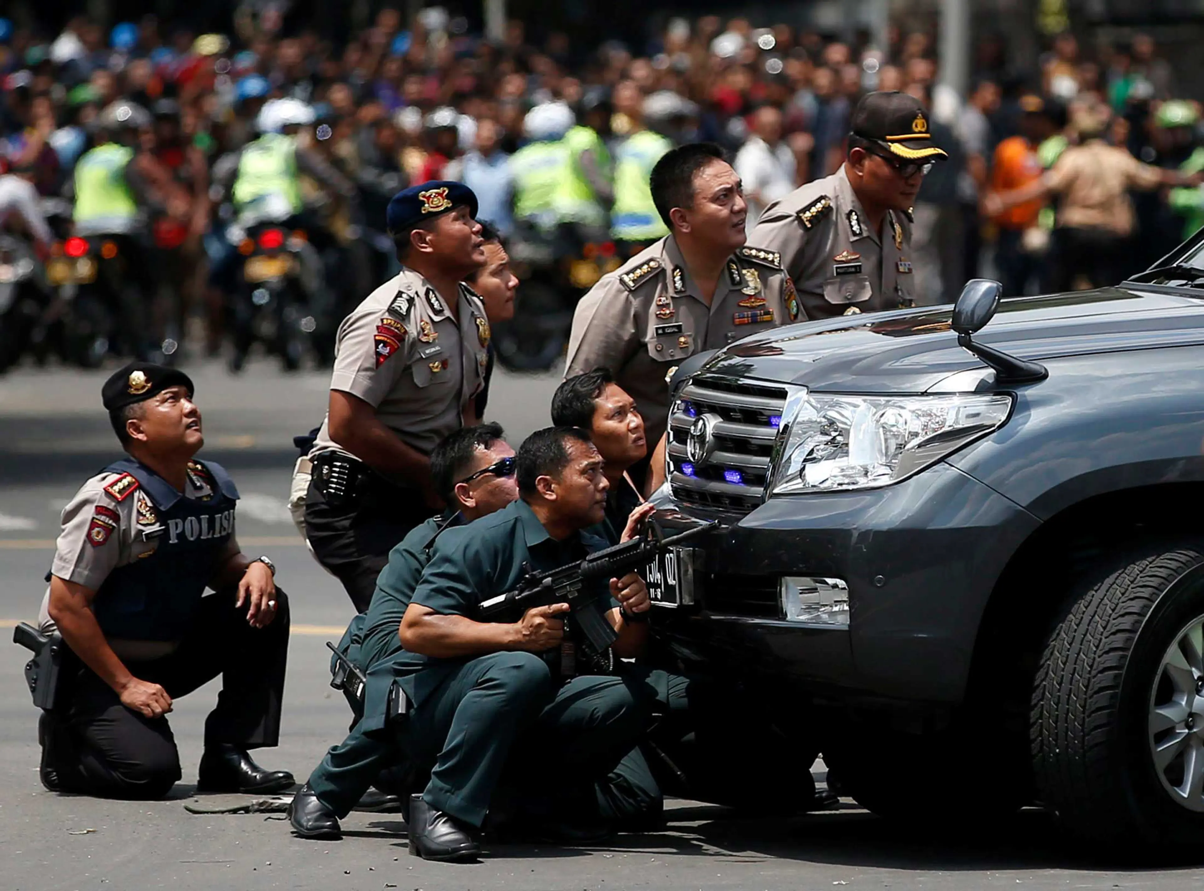Police officers react near the site of a blast in Jakarta, Indonesia, Jan.14, 2016.