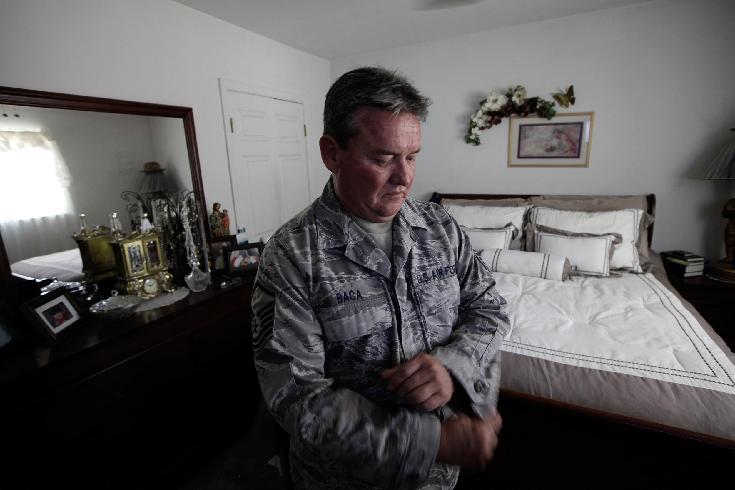 Master Sgt. Jessey Baca, who has constrictive bronchiolitis, adjusts his uniform at home on July 2, 2014