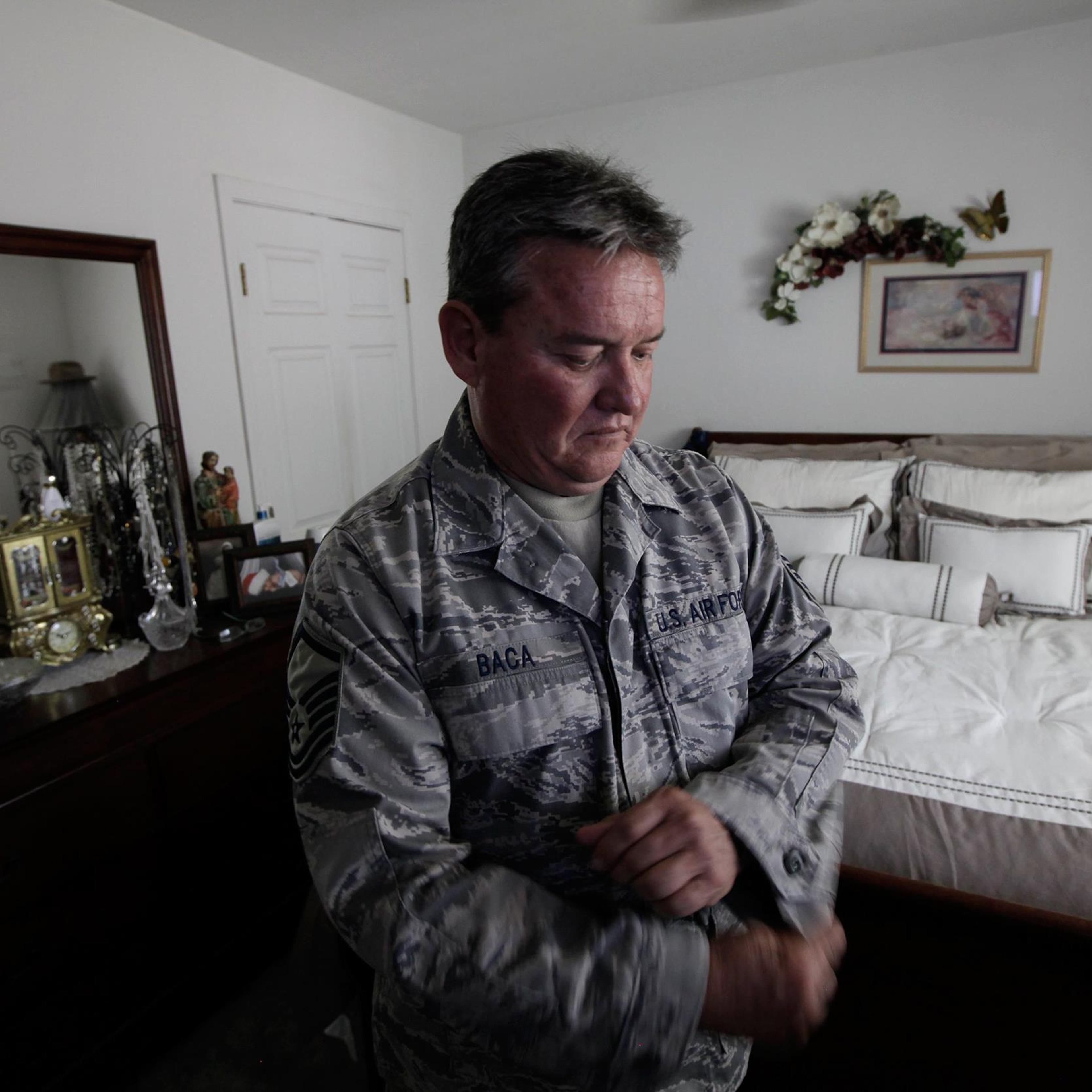 Master Sgt. Jessey Baca, who has constrictive bronchiolitis, adjusts his uniform at home on July 2, 2014