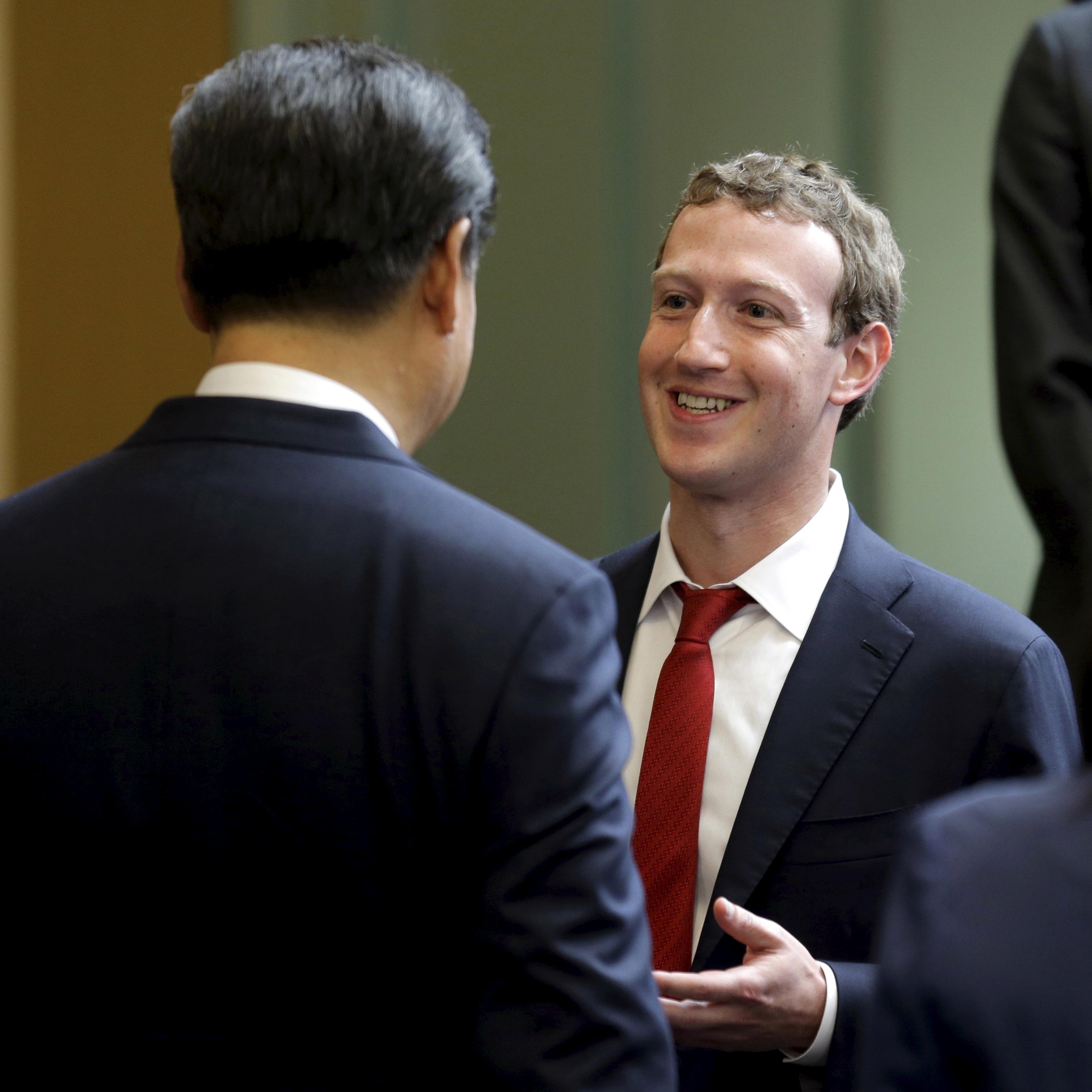 Chinese President Xi Jinping (L) talks with Facebook Chief Executive Mark Zuckerberg during a gathering of CEOs and other executives at Microsoft's main campus in Redmond, Washington