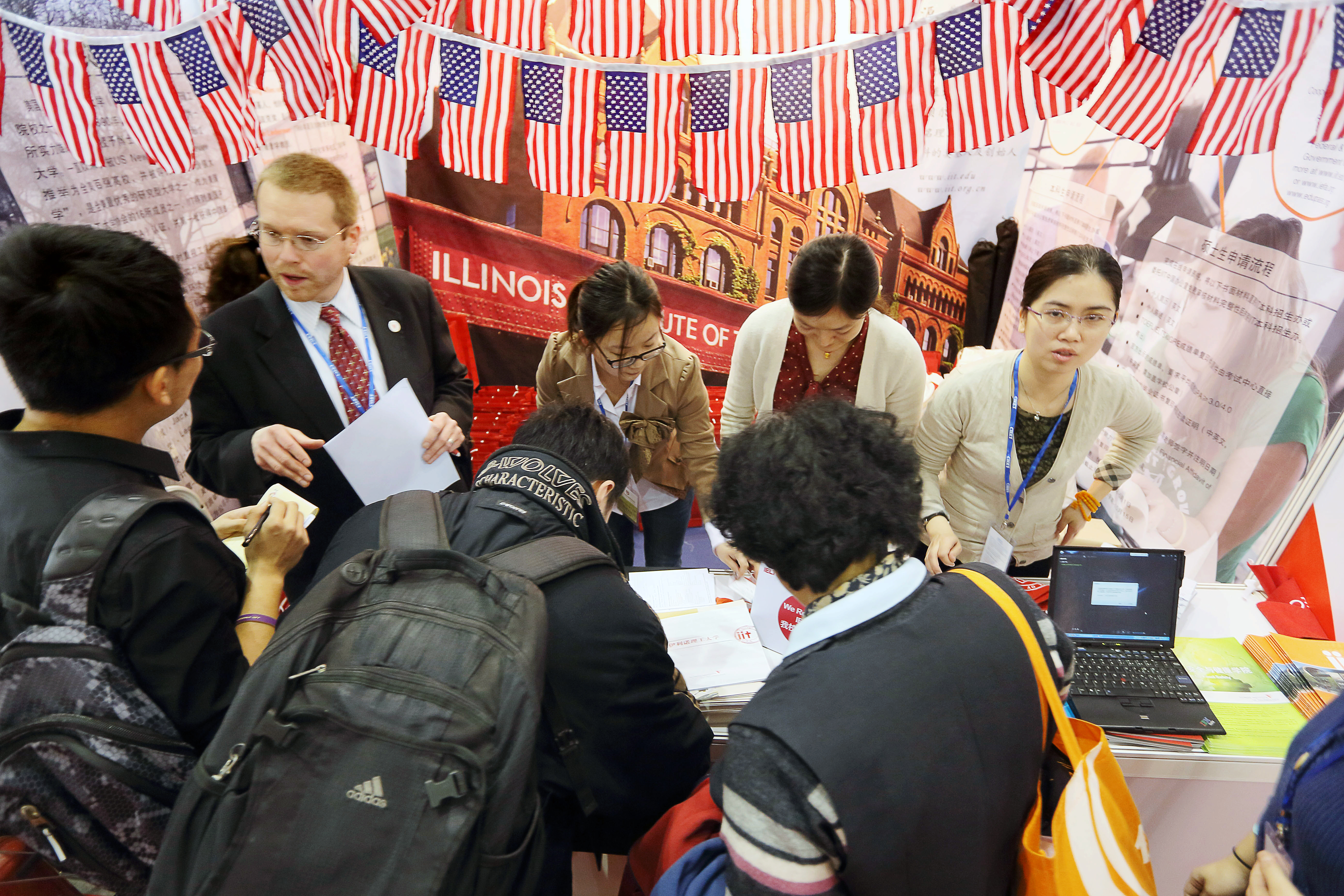 Visitors crowd the booth of an American university at the China International Education Exhibition Tour in Beijing.