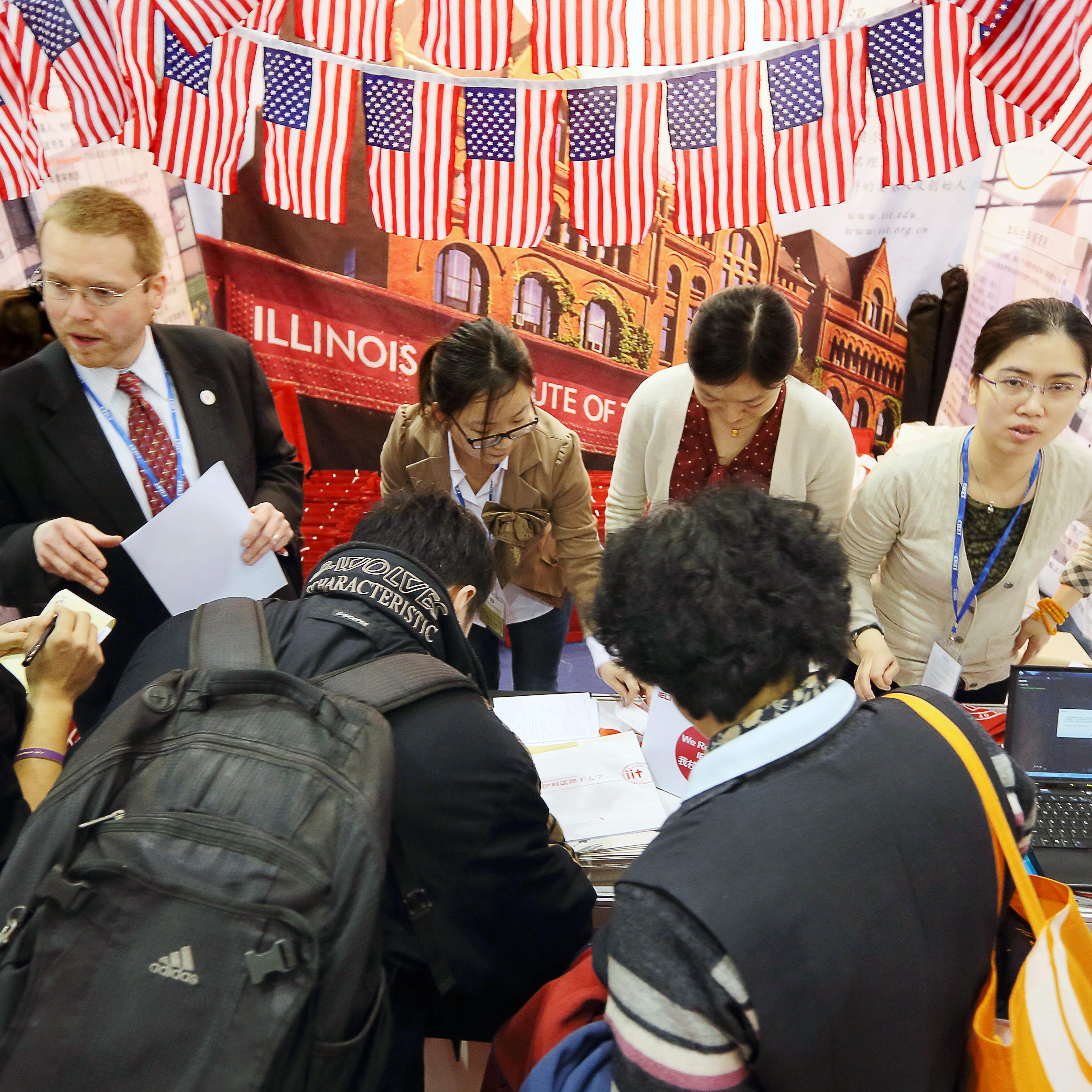 Visitors crowd the booth of an American university at the China International Education Exhibition Tour in Beijing.