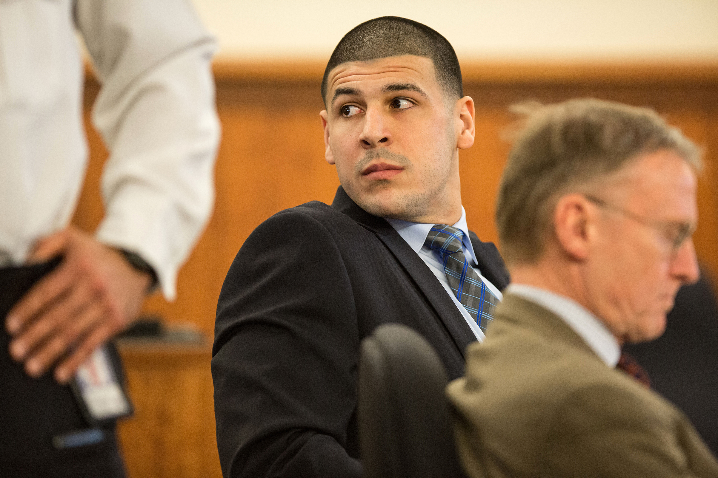 Aaron Hernandez watches as Robert Kraft entered the courtroom during the murder trial of former New England Patriots tight end at Bristol County Superior Court in Fall River, Mass.