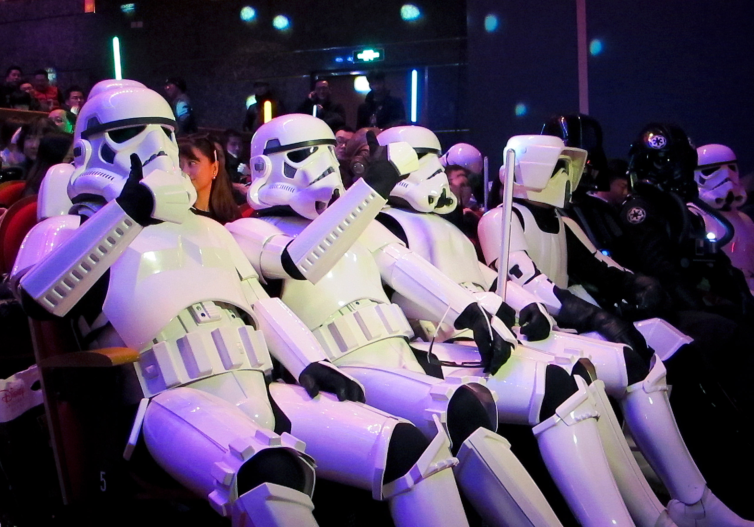 In this Sunday, Dec. 27 photo, Chinese fans, dressed as Star Wars character Stormtroopers, gesture as they arrive for the premiere of "Star Wars: The Force Awakens" in Shanghai, China. The movie has already broken the $1 billion mark, and it hasn’t even 